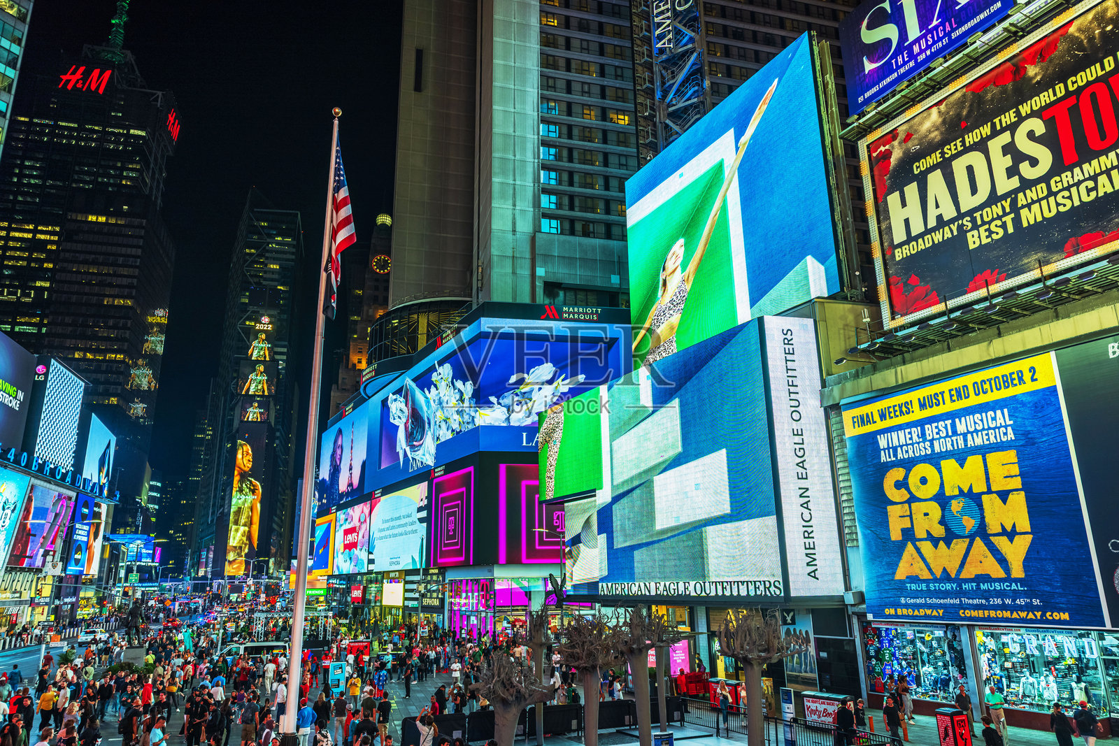 时代广场的迷人夜景，有闪耀的广告牌、人群和明亮的城市灯光。照片摄影图片