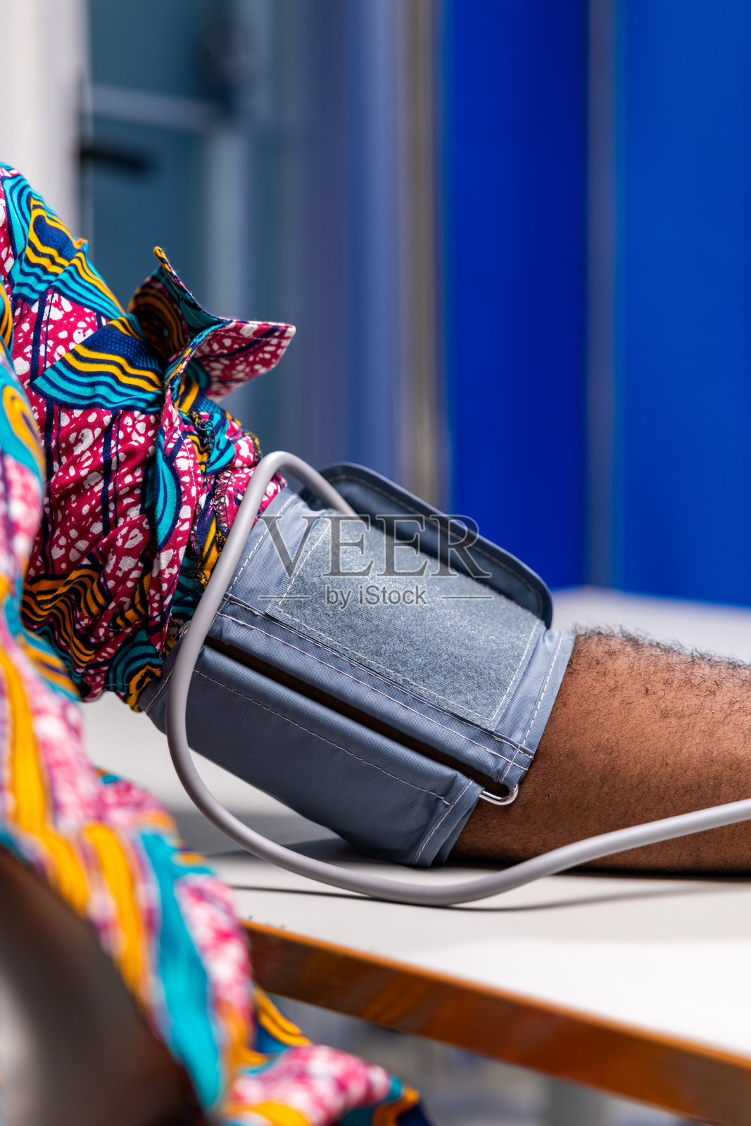 医院里，男性患者手臂佩戴血压袖带，监测生命体征的特写照片摄影图片