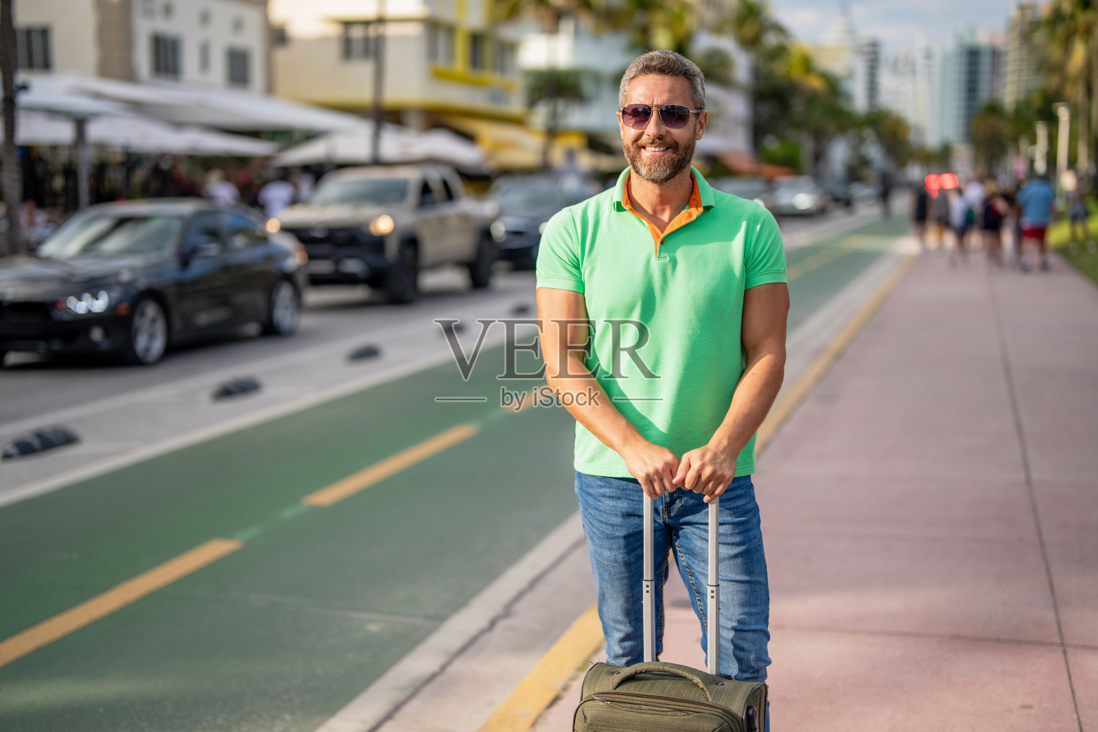 40多岁的旅行者。夏日度假游客。夏季度假旅行行李。享受夏日旅程的旅行者。西班牙裔游客在城市街道上行走。带行李箱的游客。旅游目的地照片摄影图片