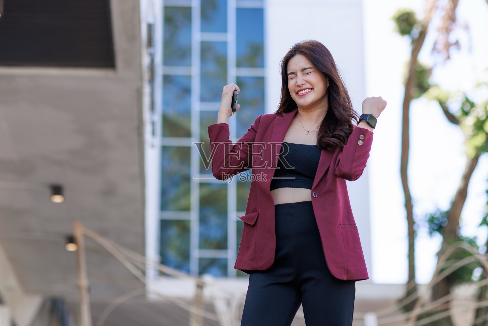 年轻的亚洲女商人在挥舞拳头庆祝成功照片摄影图片