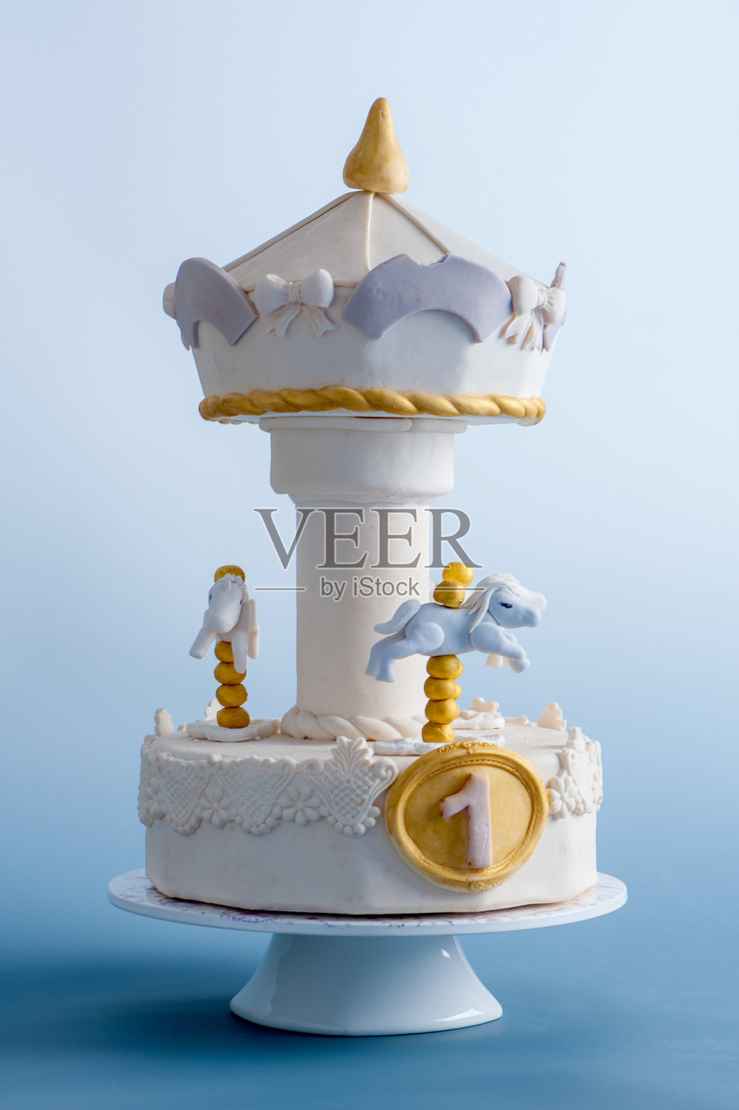富有想象力的旋转木马生日蛋糕，上面有马匹和数字“1”照片摄影图片