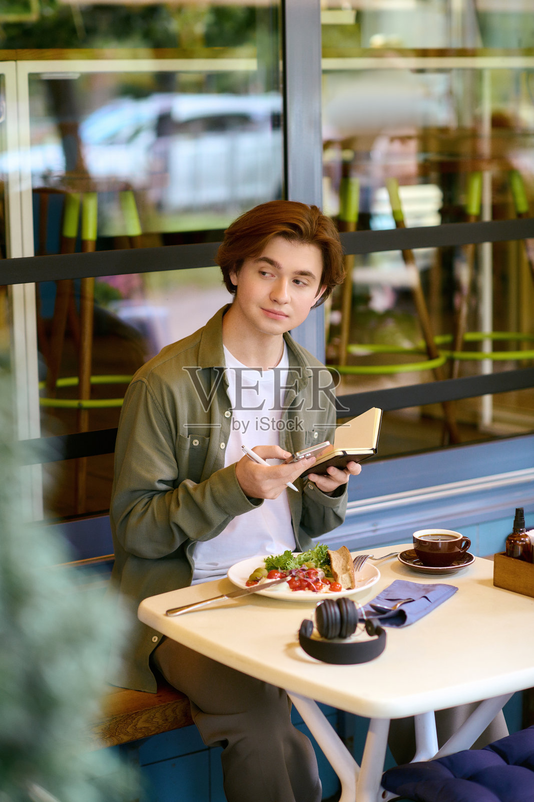 年轻男子在明亮现代的咖啡馆里享用美味佳肴照片摄影图片