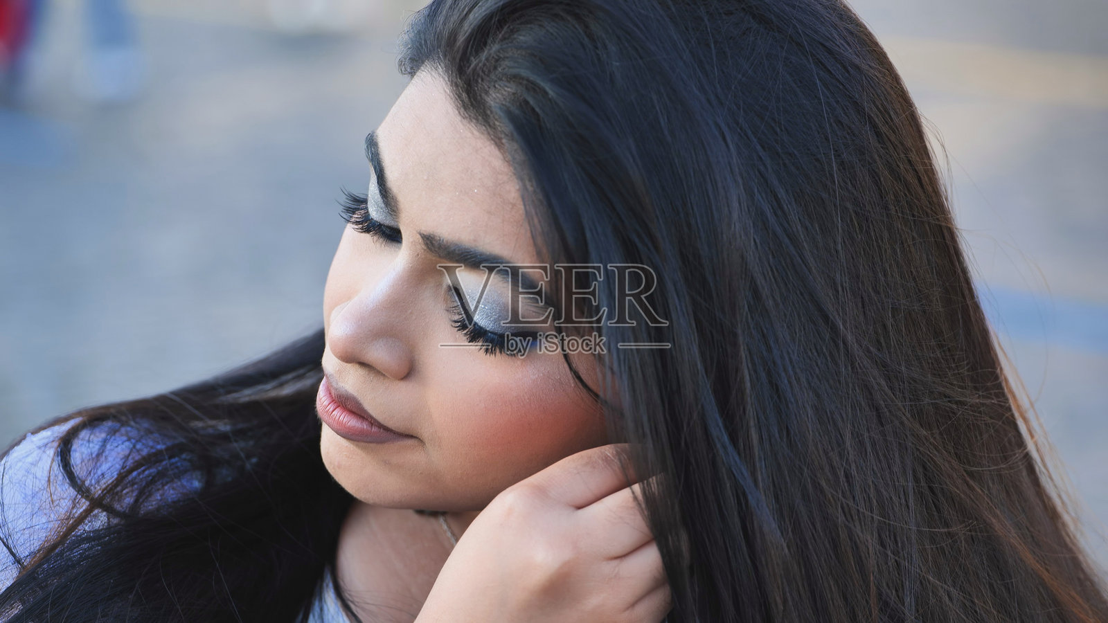 一位年轻的孟加拉国女性在莫斯科闭眼化妆，摆出造型照片摄影图片