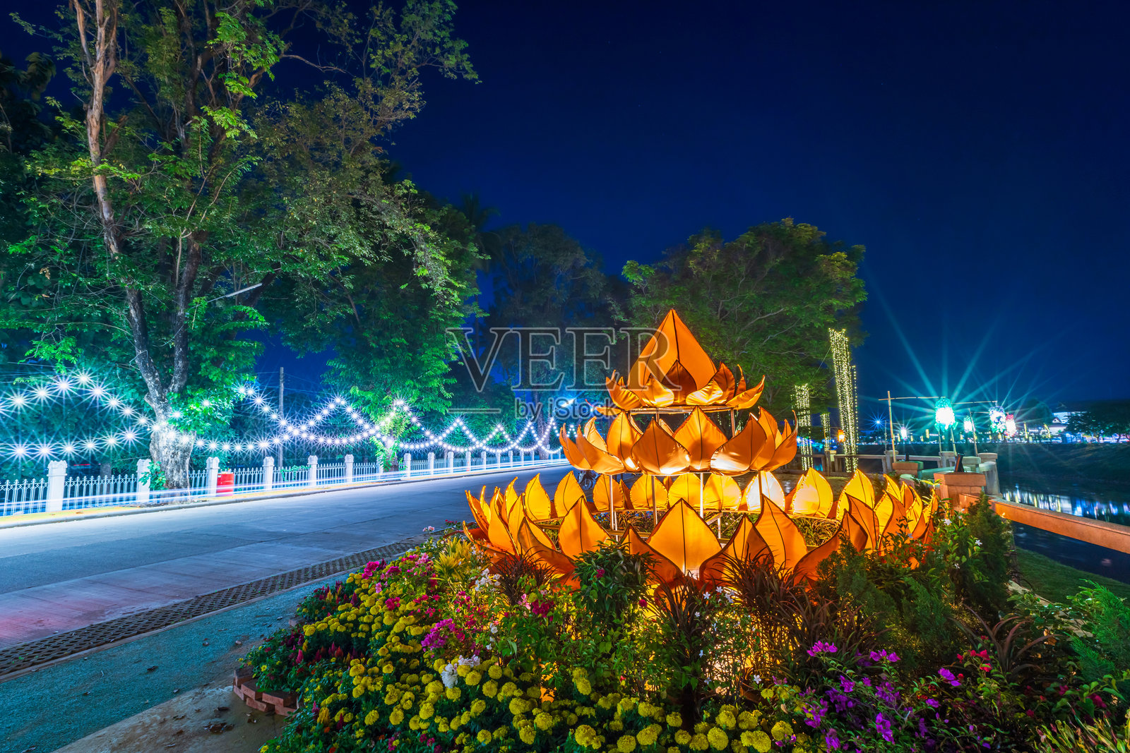 2024年洛伊·克拉通节期间，在泰国著名的普拉宋克拉纳雷宣桥前，夜晚制作的装饰精美的浅色水灯，值此泰历十二月满月之际。照片摄影图片