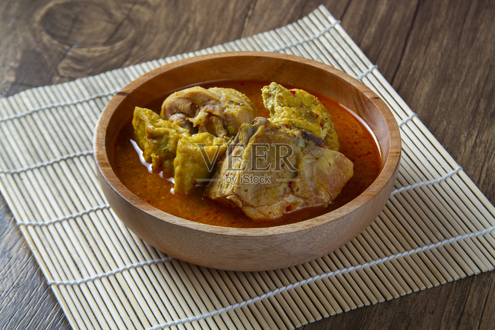 椰奶印尼鸡肉咖喱（Gulai Ayam）盛放在木盘上照片摄影图片
