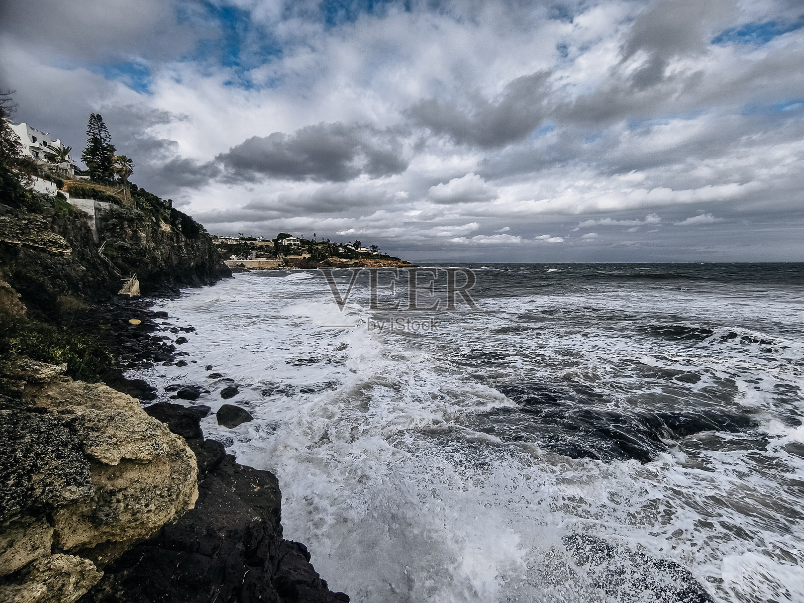 西西里岛的岩石海岸：地中海沿岸，汹涌的海浪拍打着崎岖的悬崖，天空布满戏剧性的云朵照片摄影图片