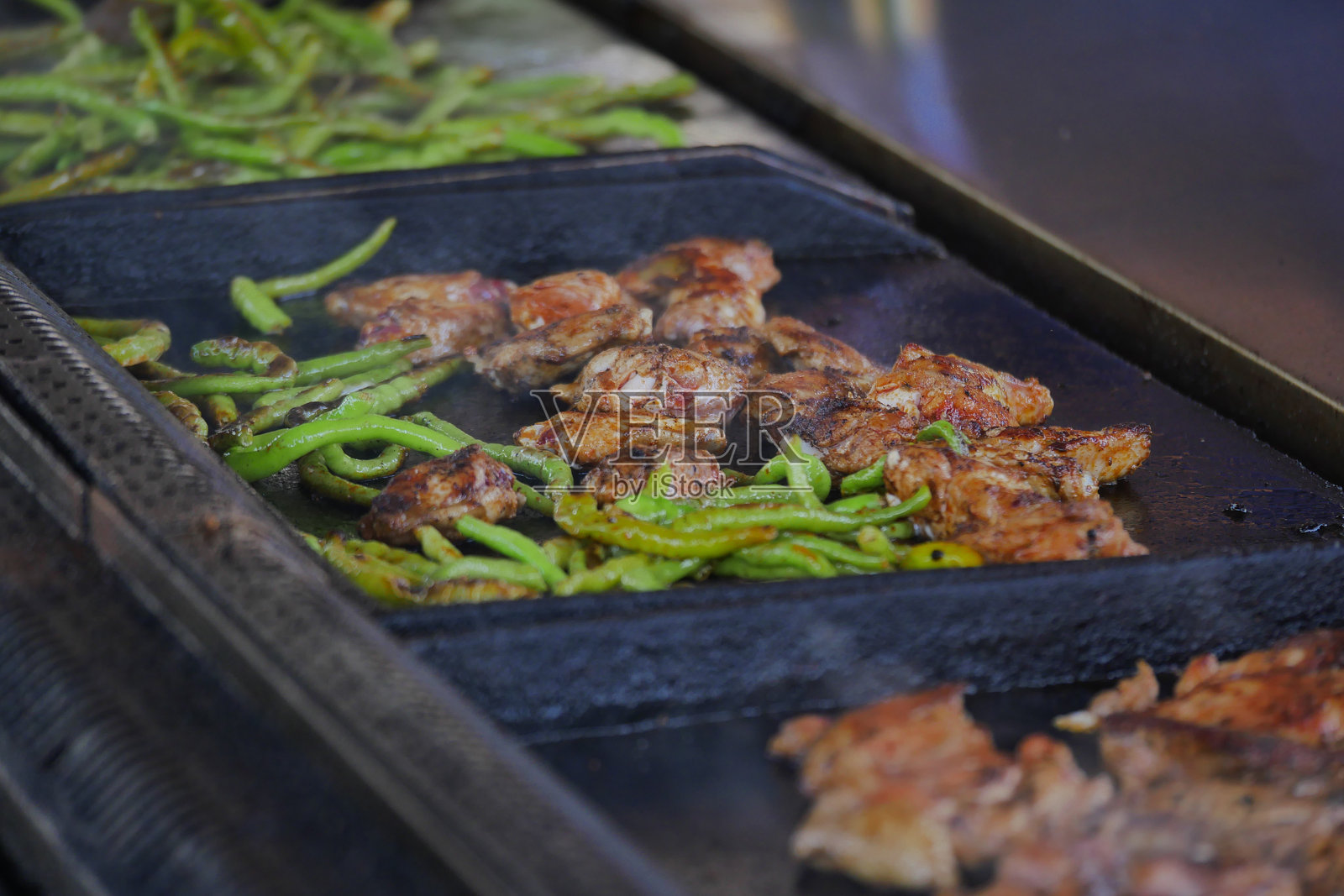 小吃摊上烤架上滋滋作响的烤鸡和彩椒照片摄影图片