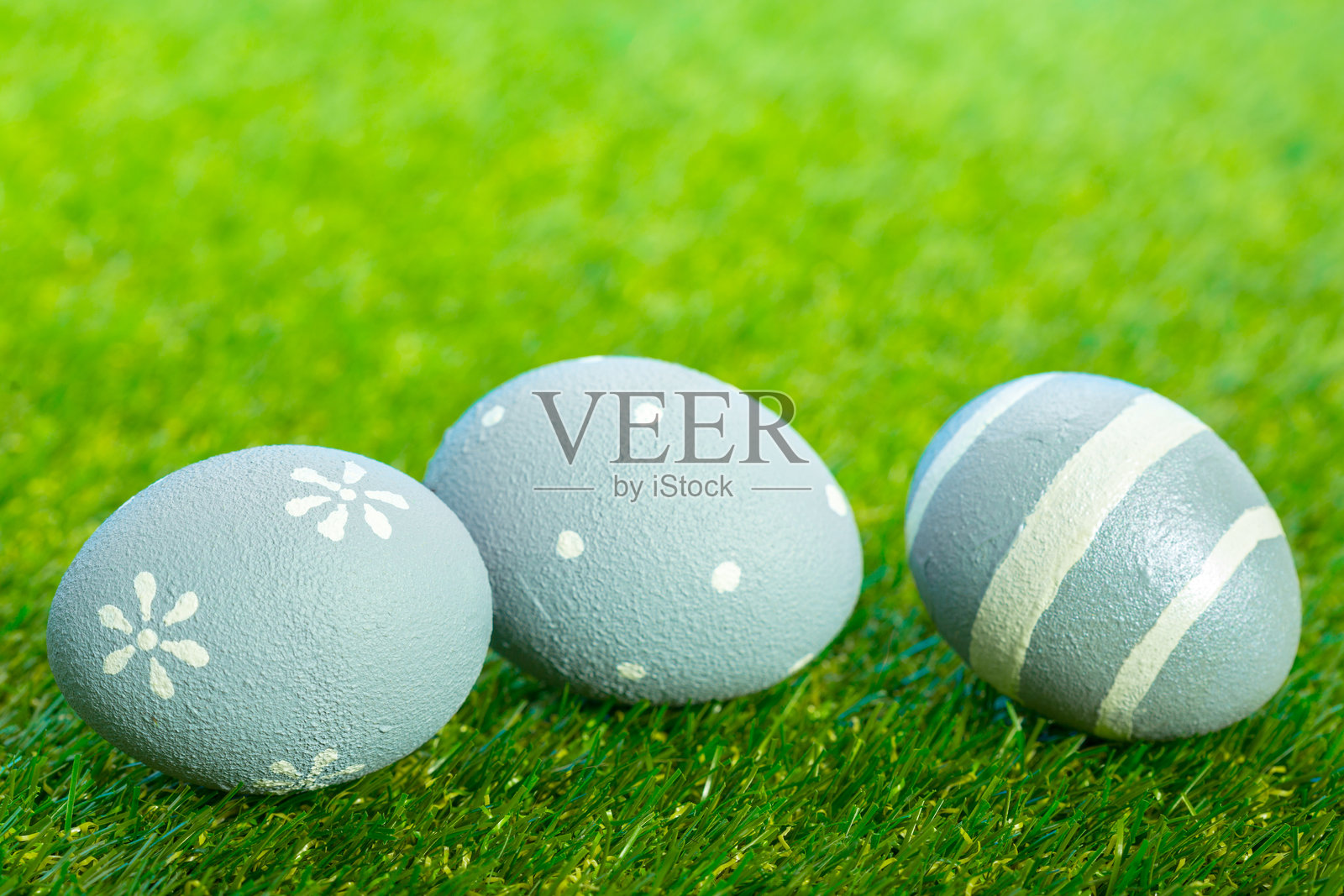 五彩的鸡蛋放在绿草地上，用于春季庆祝或装饰活动照片摄影图片