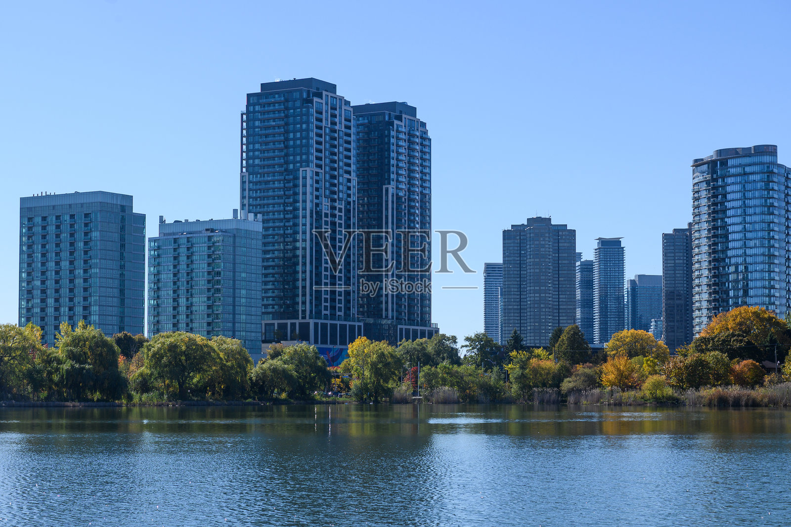 多伦多艾托比科的城市天际线，有现代建筑、秋季树木和水景照片摄影图片