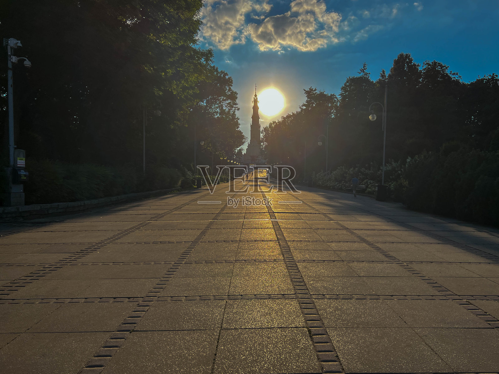 夕阳接近地平线，位于波兰琴斯托霍瓦市琴斯托霍瓦圣地雅斯纳山后面的塔楼照片摄影图片