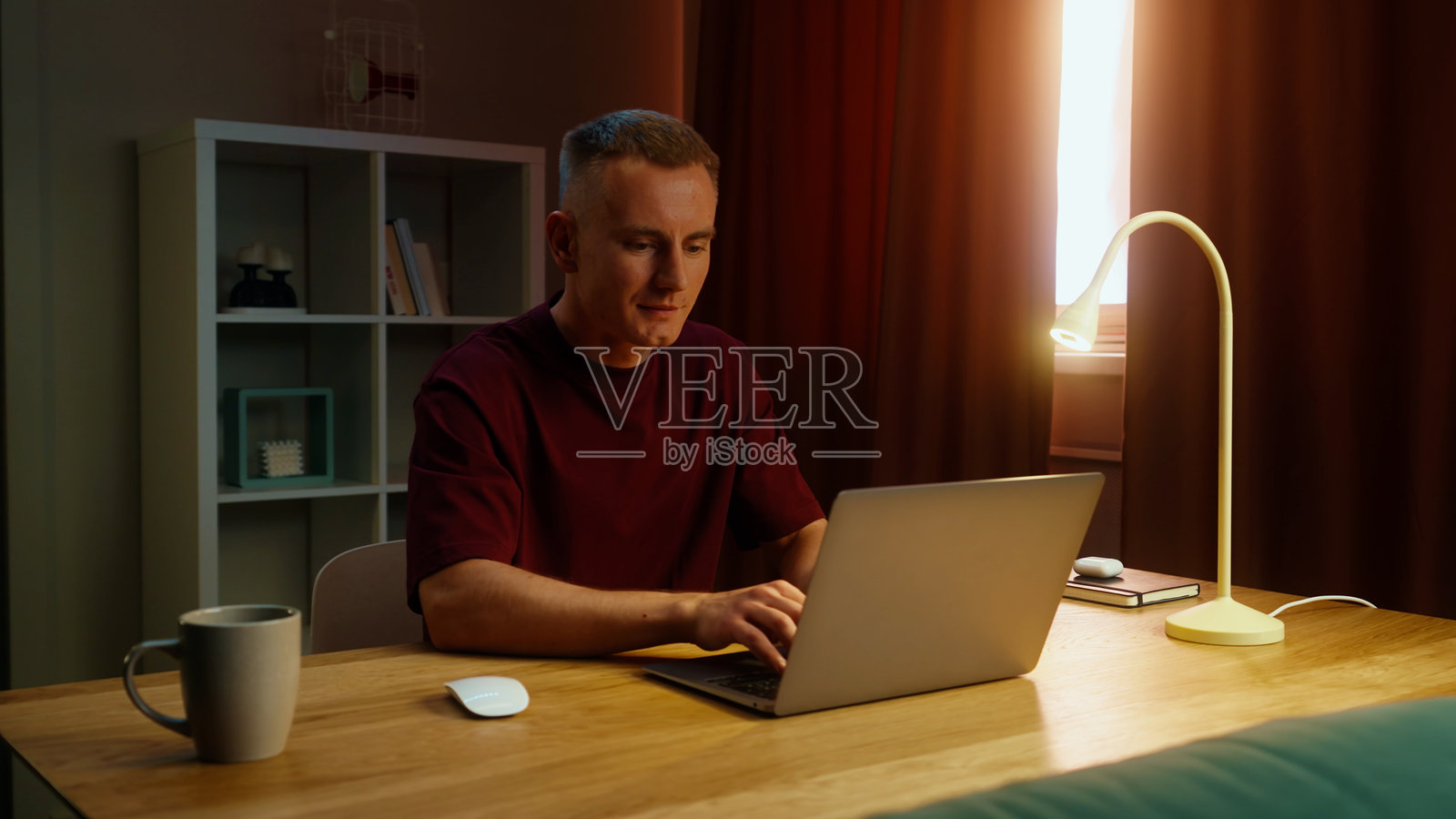 自由职业者在家办公，坐在桌子旁使用打开的笔记本电脑。远程在线工作。照片摄影图片