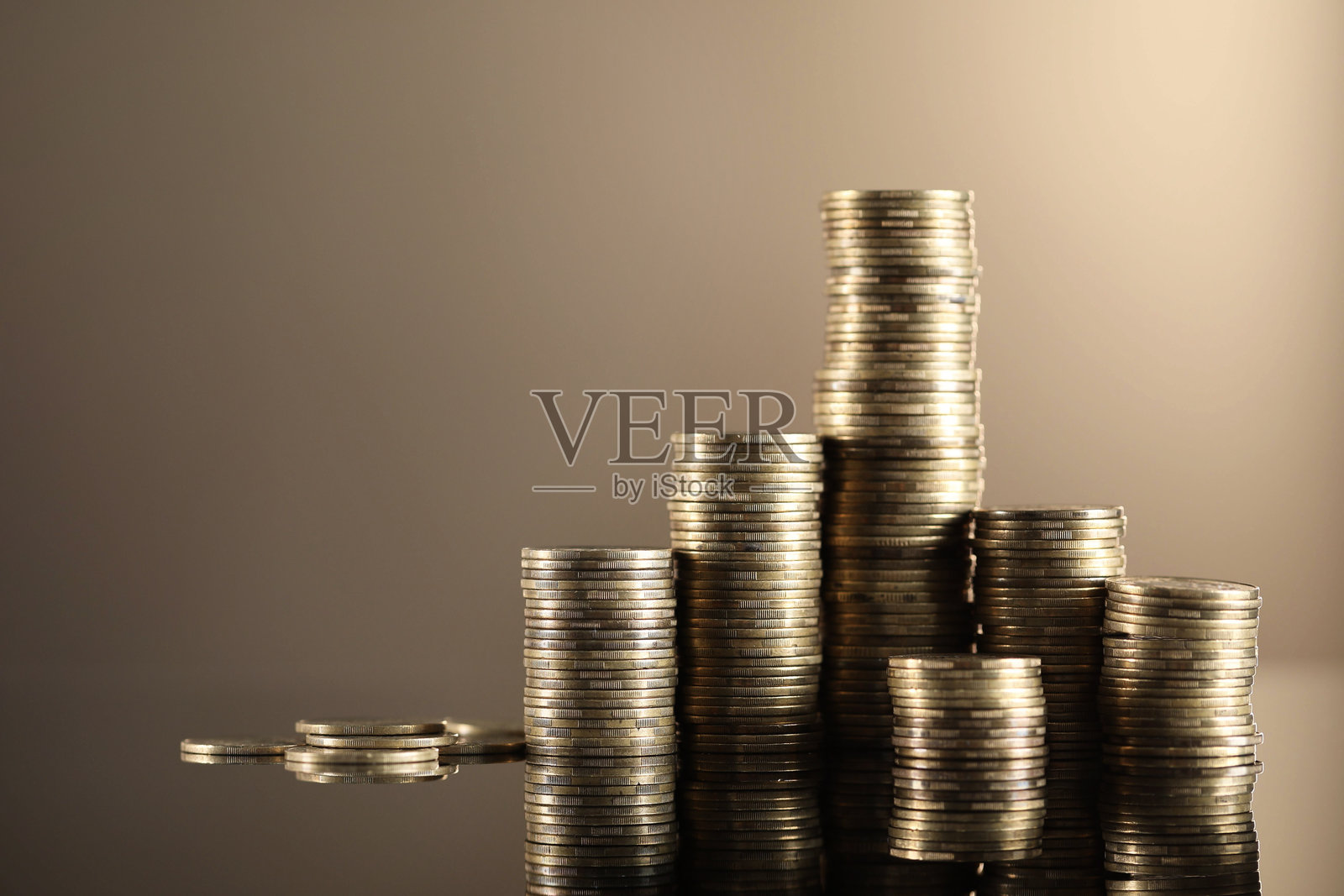 米色镜面特写，堆叠的硬币。留有文字空间照片摄影图片