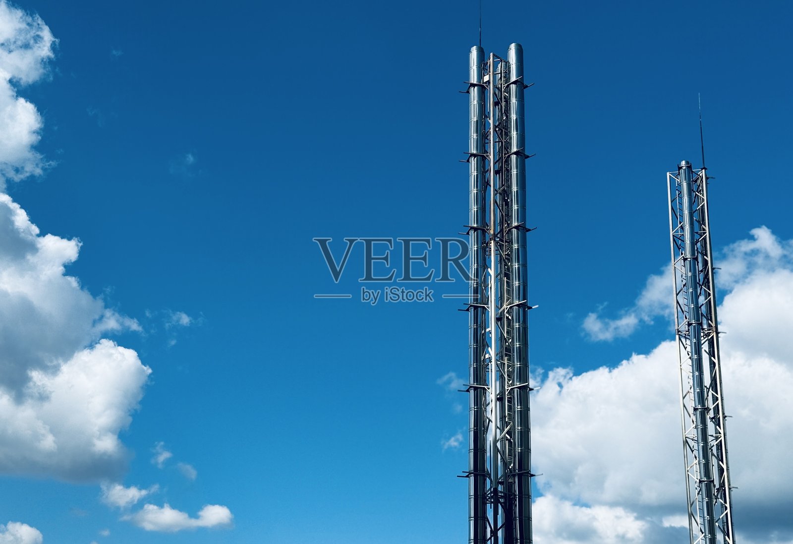 金属城市景观，金属塔的城市景观，以金属结构和管道为特色的工业天际线，垂直金属框架和烟囱主导着城市工业景观照片摄影图片