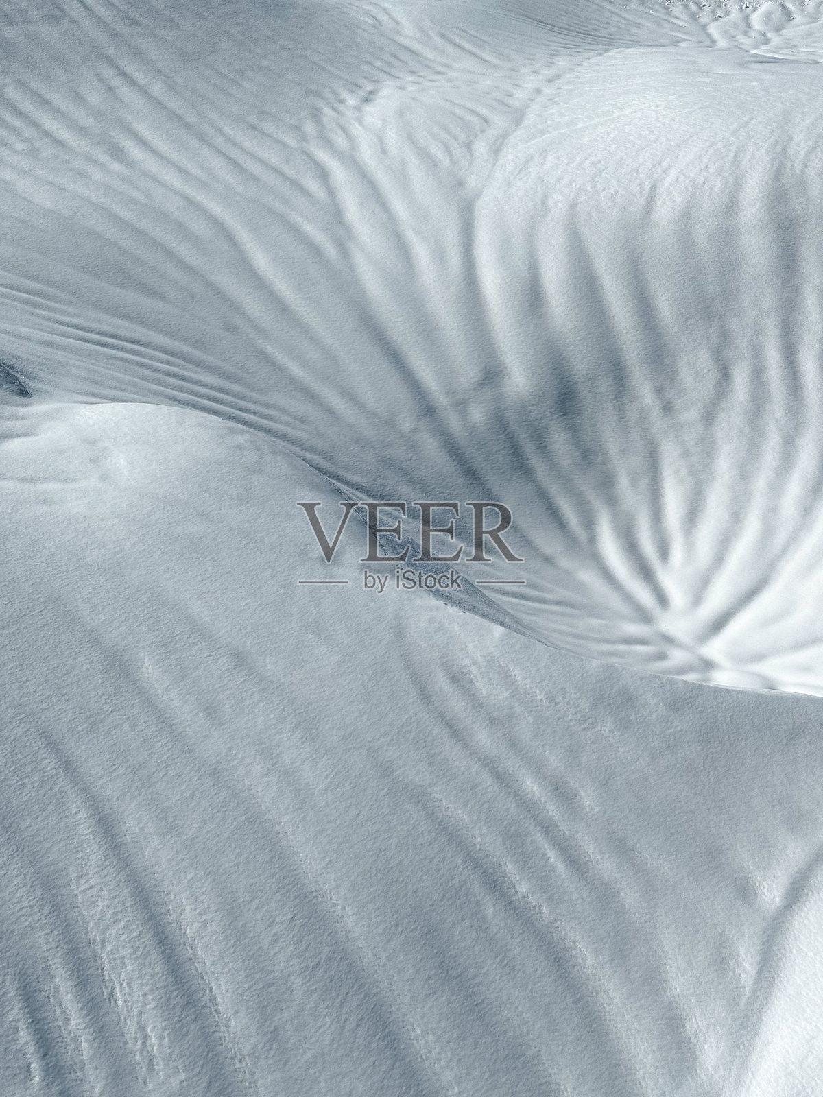 特写：雪地表面有被风雨塑造的柔和纹理和质感照片摄影图片