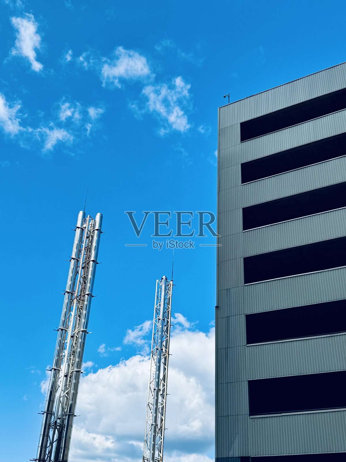 金属城市景观，金属塔的城市景观，工业天际线，以金属结构和管道为特色，垂直金属框架和烟囱主导着城市工业景象照片摄影图片