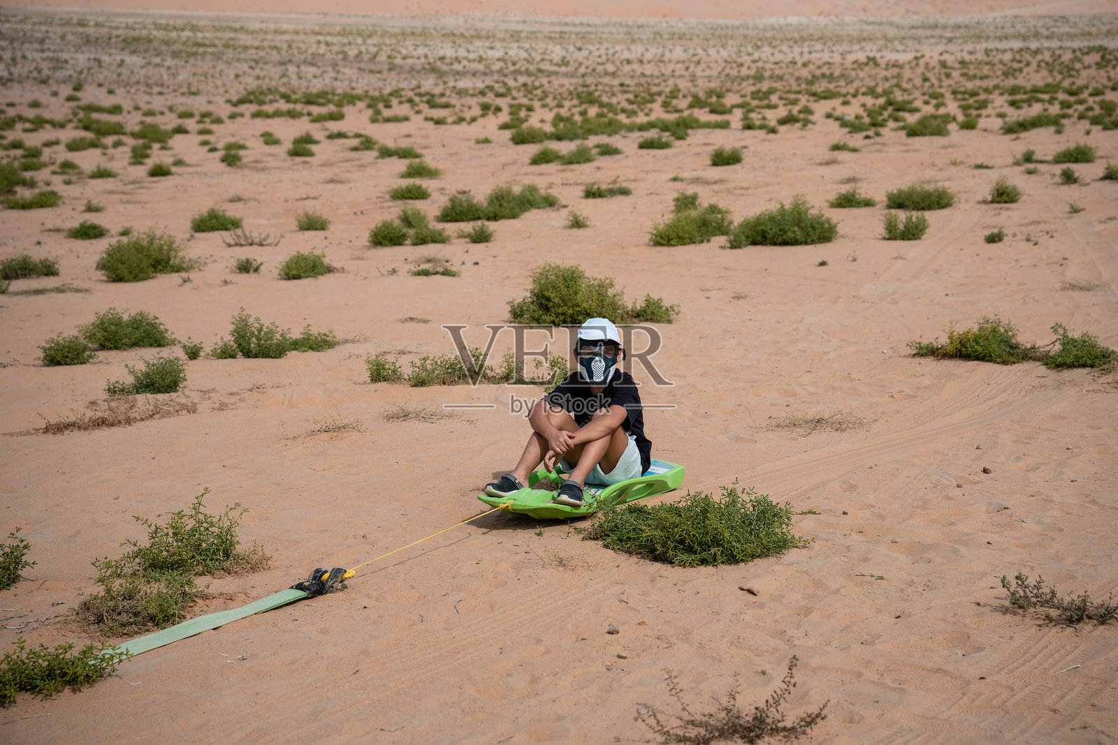 孩子在沙漠景观中玩滑沙的乐趣照片摄影图片