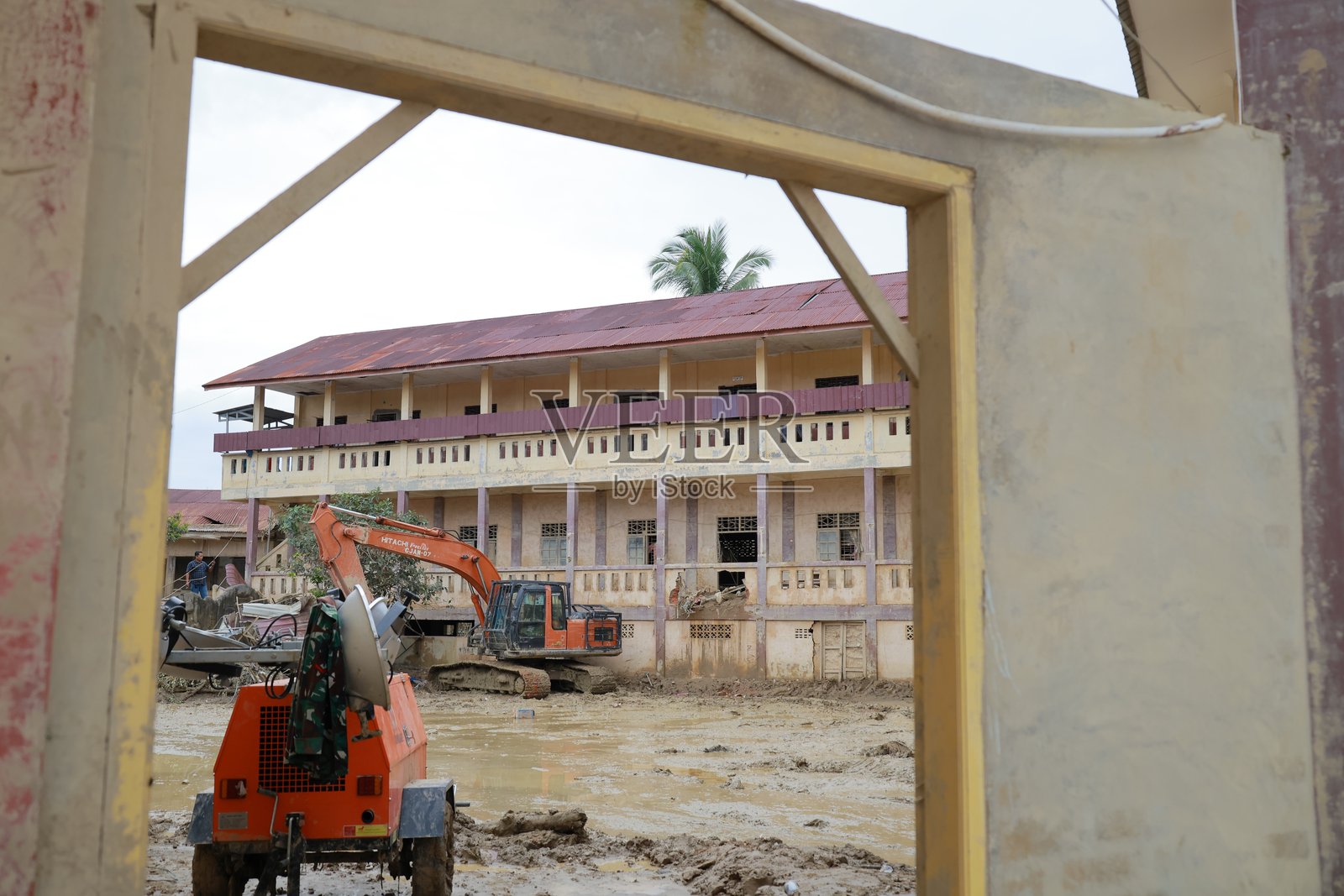 亚齐 Tamiang 地区，洪水受损的伊斯兰寄宿学校现场的重型设备照片摄影图片