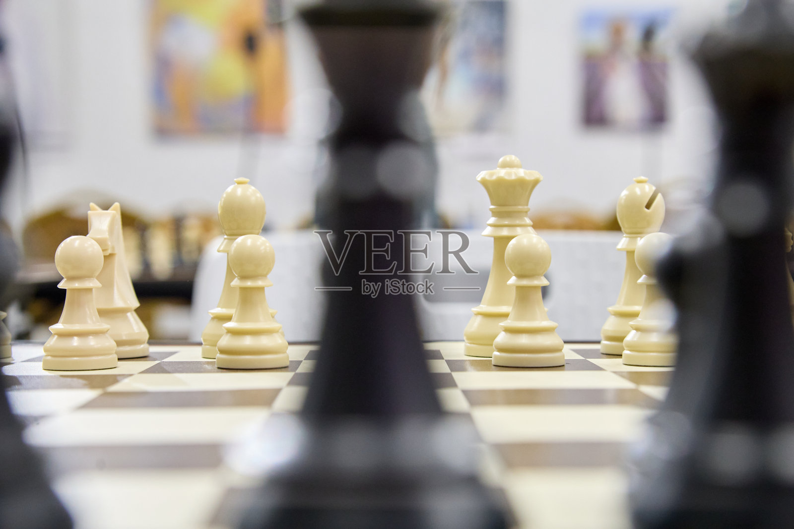 特写白色棋子在棋盘上，背景虚化，强调室内宁静环境中策略、专注和智力博弈。照片摄影图片