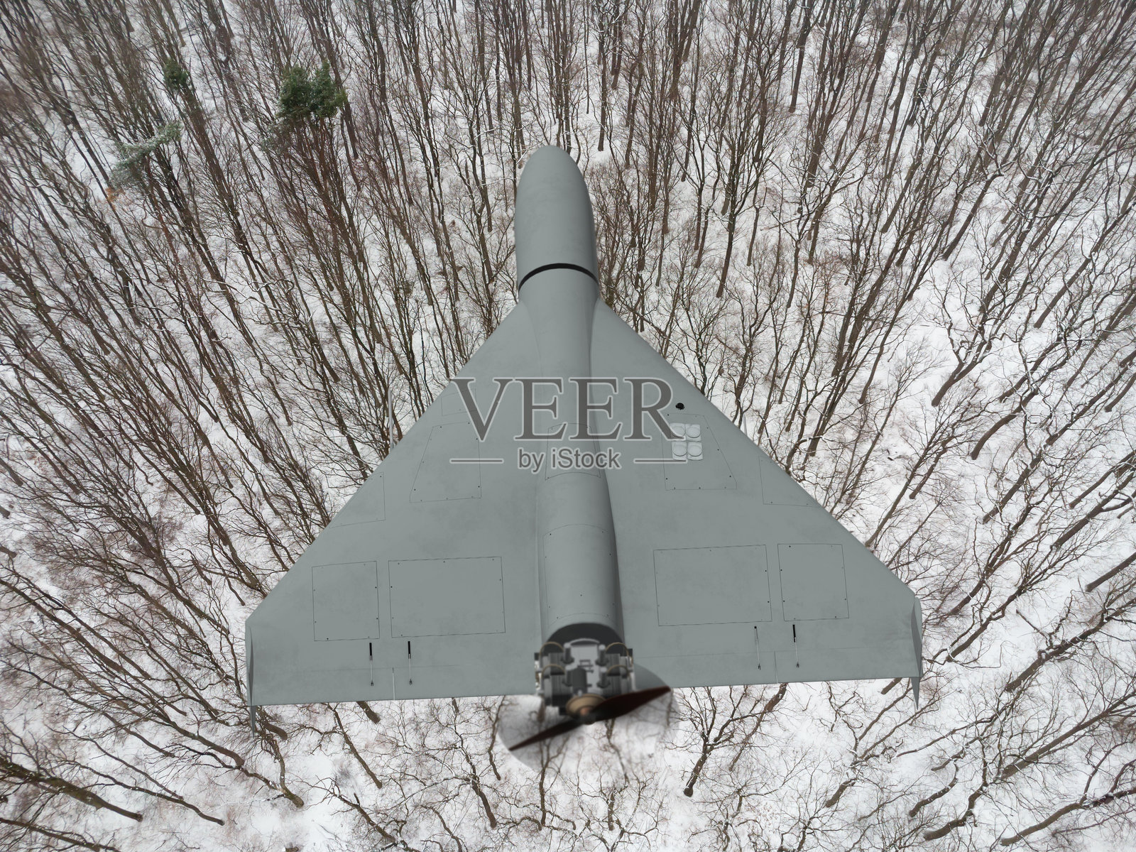 现代军用无人机在严寒的冬季森林上空执行飞行任务照片摄影图片