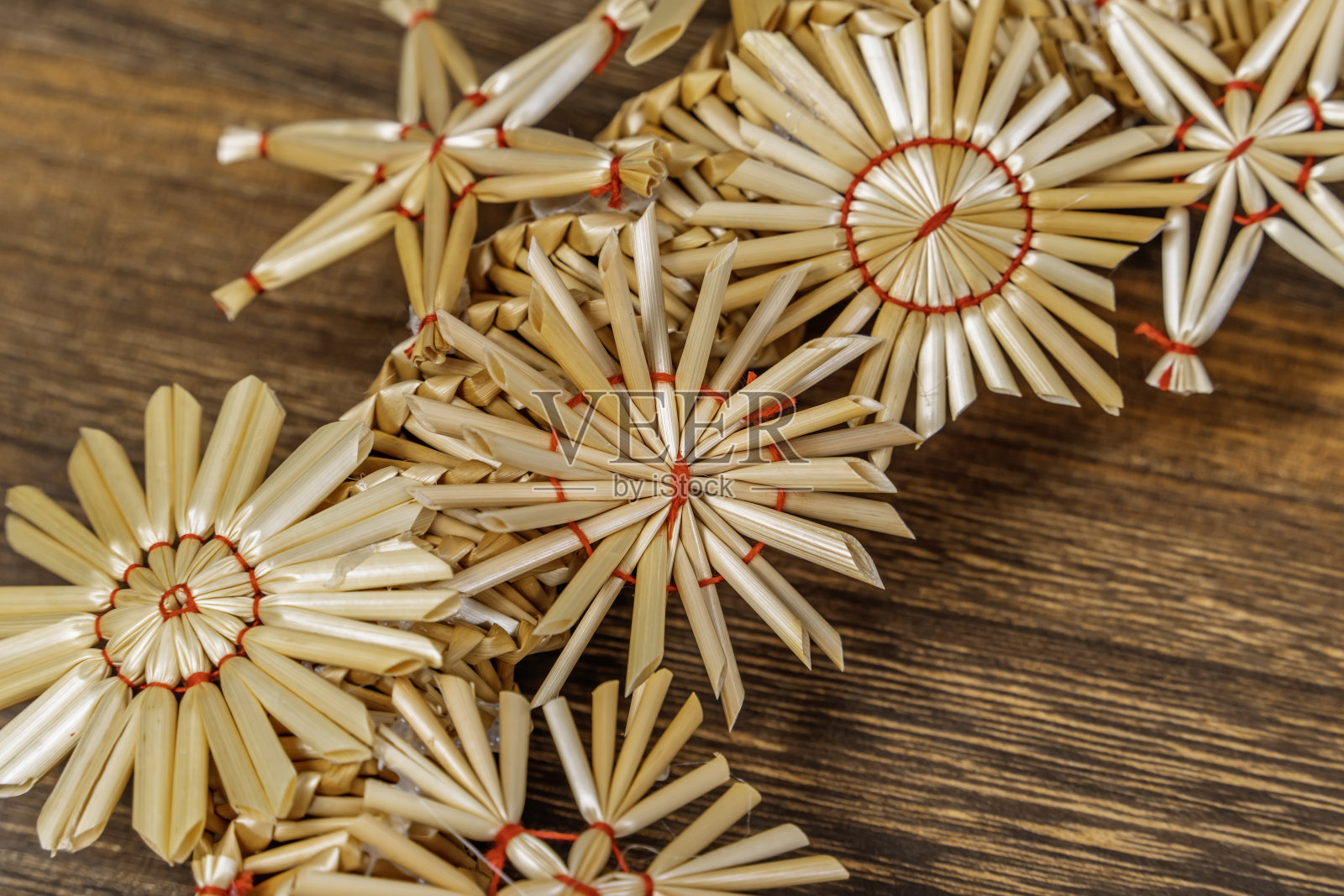 木质背景上的稻草星星。圣诞树装饰品由稻草制成。照片摄影图片