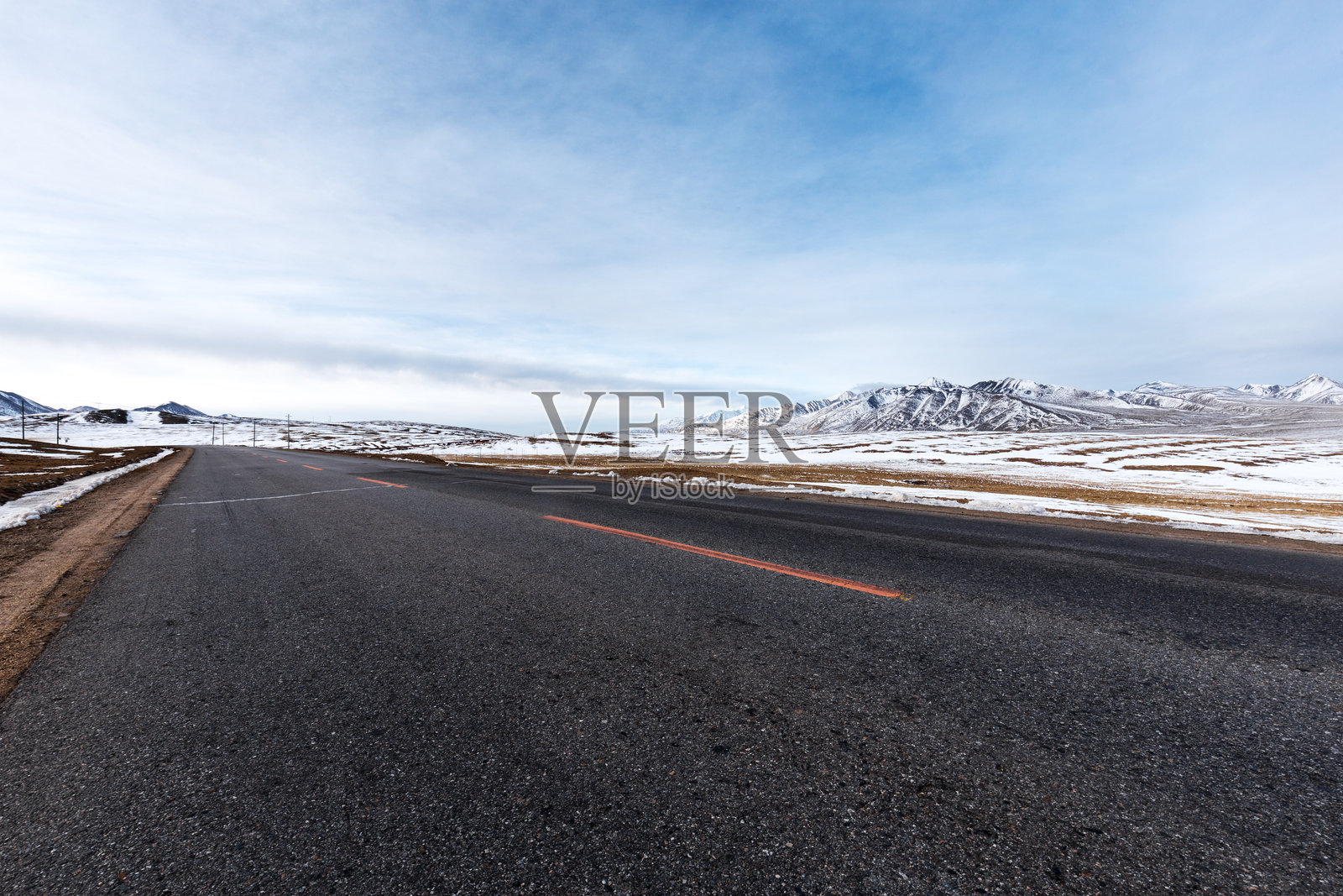 雪后高原柏油公路延伸至远山脚下照片摄影图片