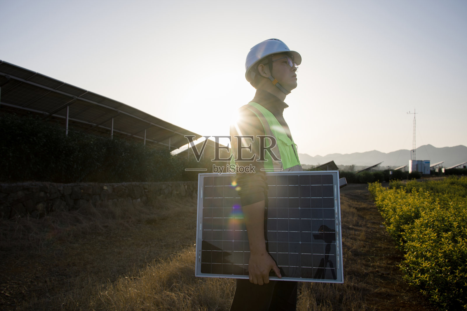 工程师持光伏板巡视太阳能电站照片摄影图片