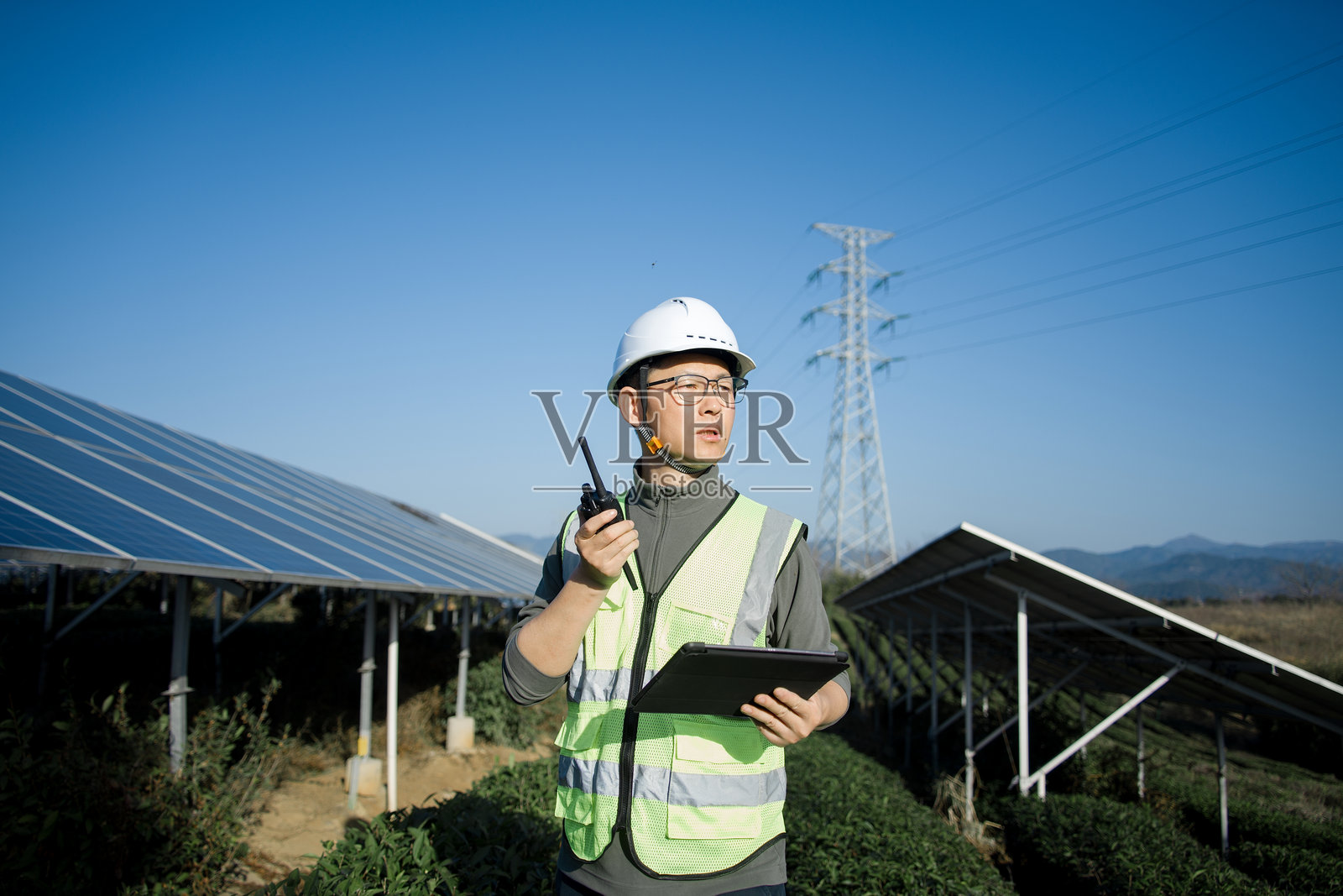 光伏电站工程师手持对讲机巡检作业照片摄影图片