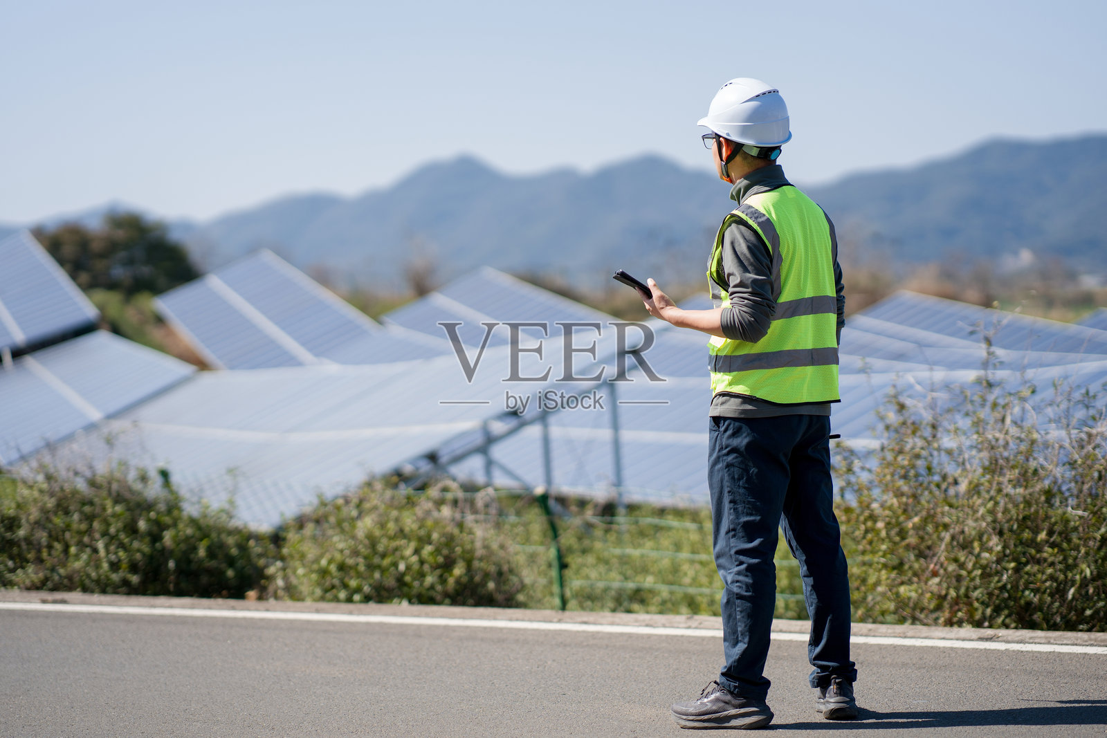 光伏电站巡检工程师手持平板查看照片摄影图片