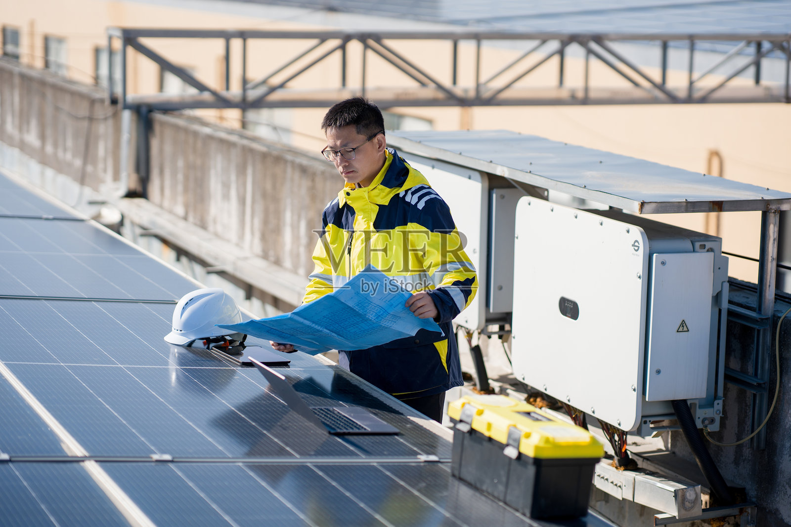 光伏工程师屋顶查看图纸检查设备照片摄影图片