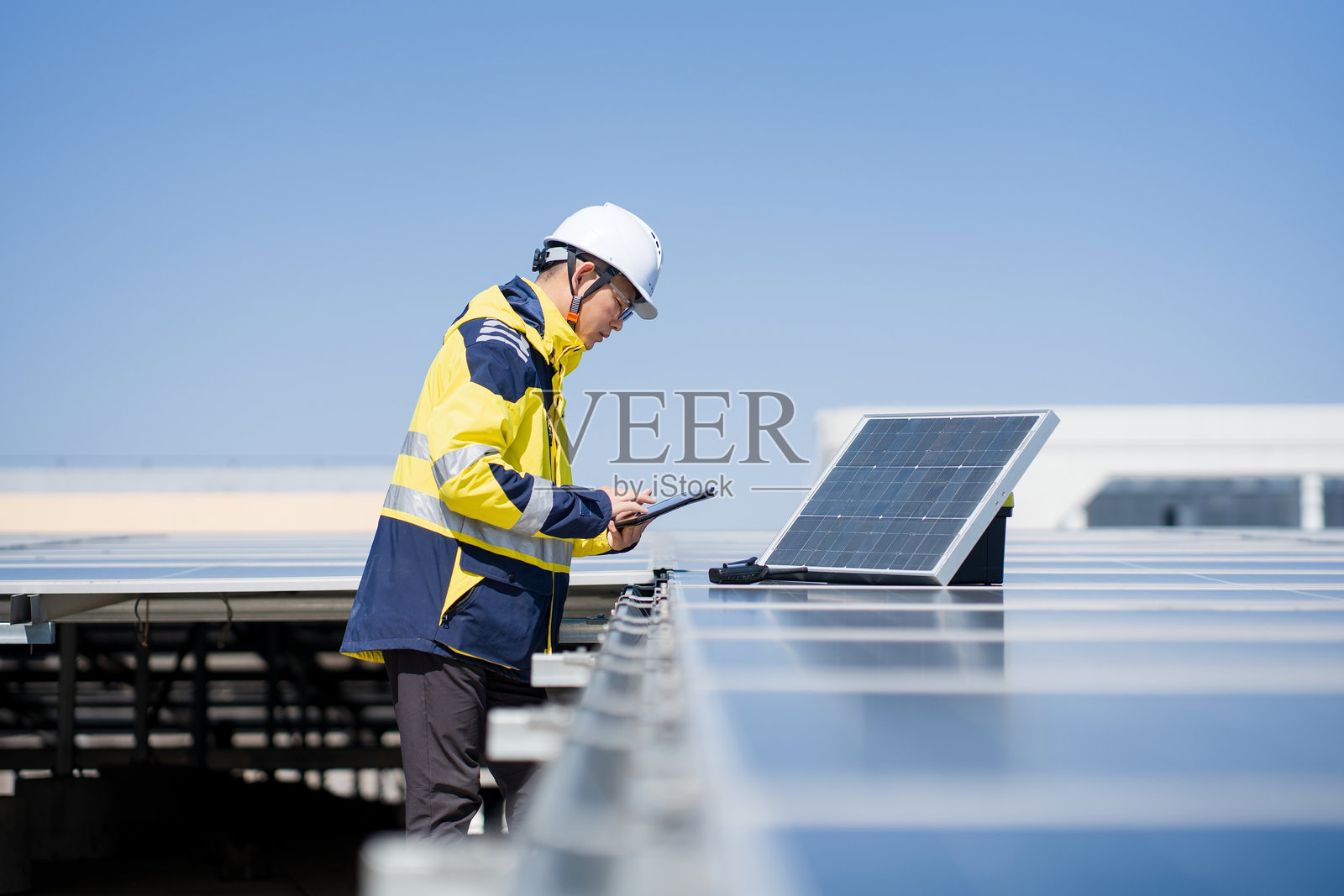 工程师戴安全帽检查屋顶光伏板照片摄影图片