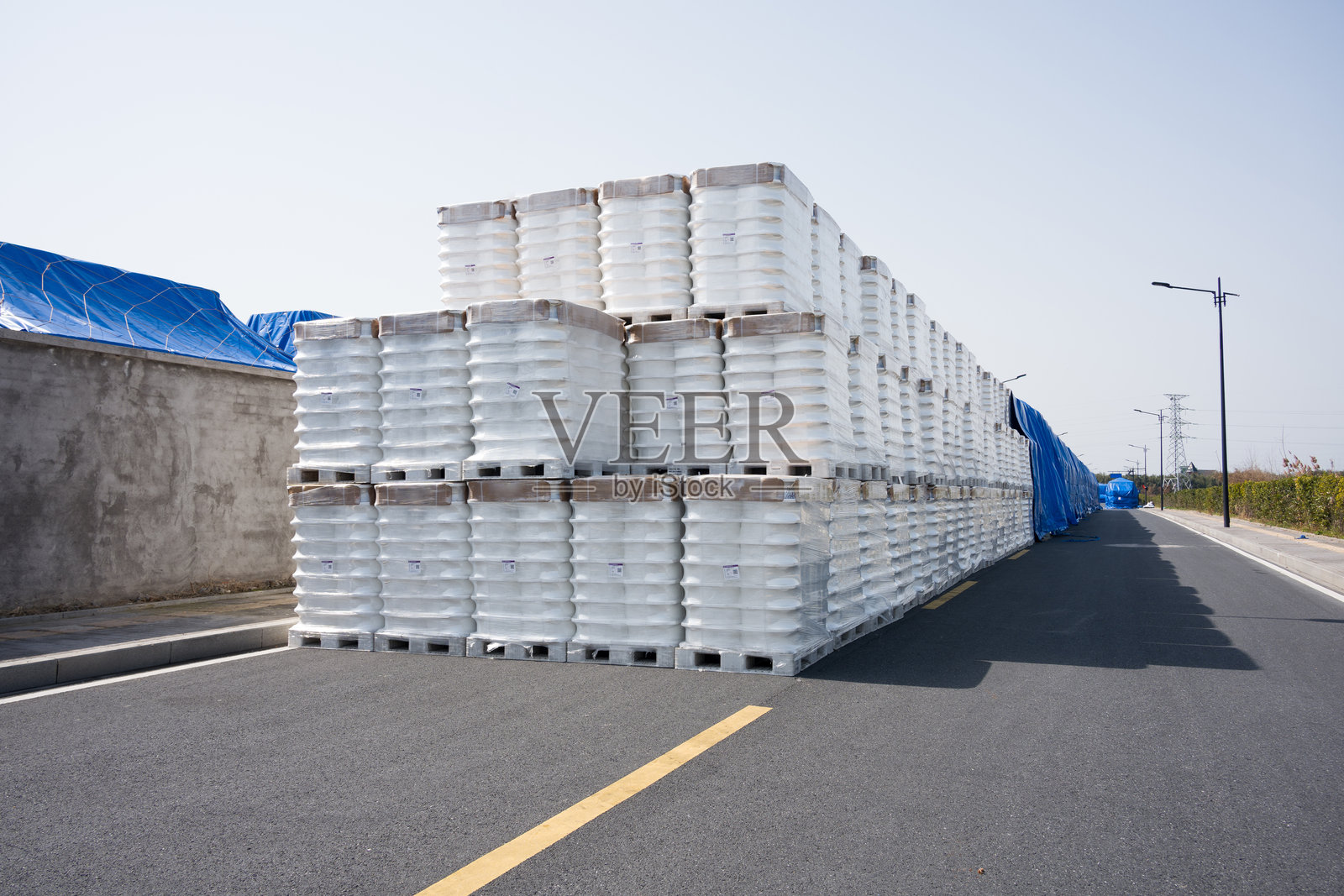 道路旁堆叠白色塑料桶货物仓储场景照片摄影图片