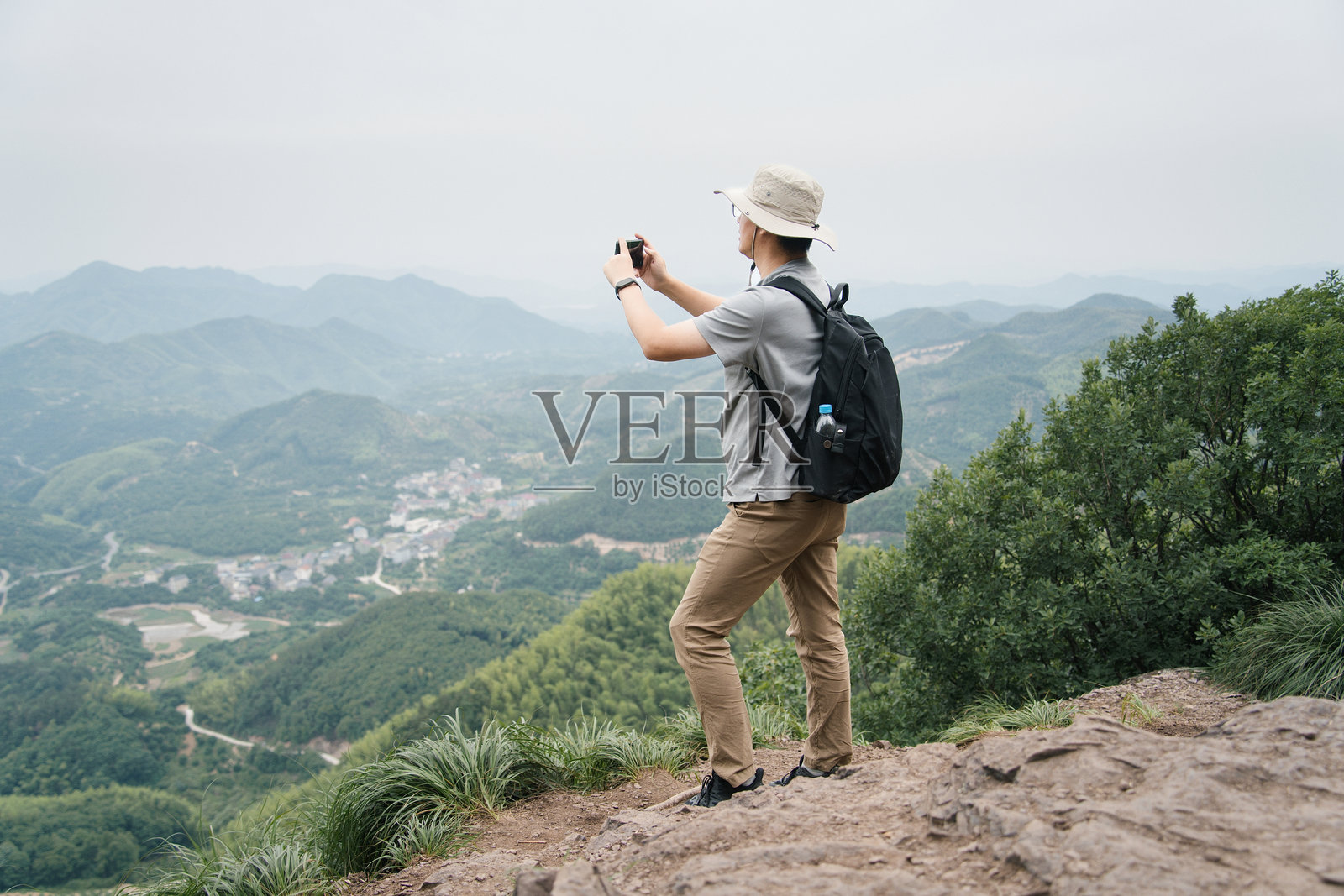 男子山顶拍山峦村落照片摄影图片