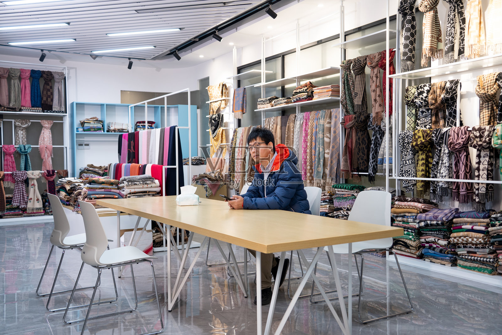 男士在布料展厅内看手机照片摄影图片