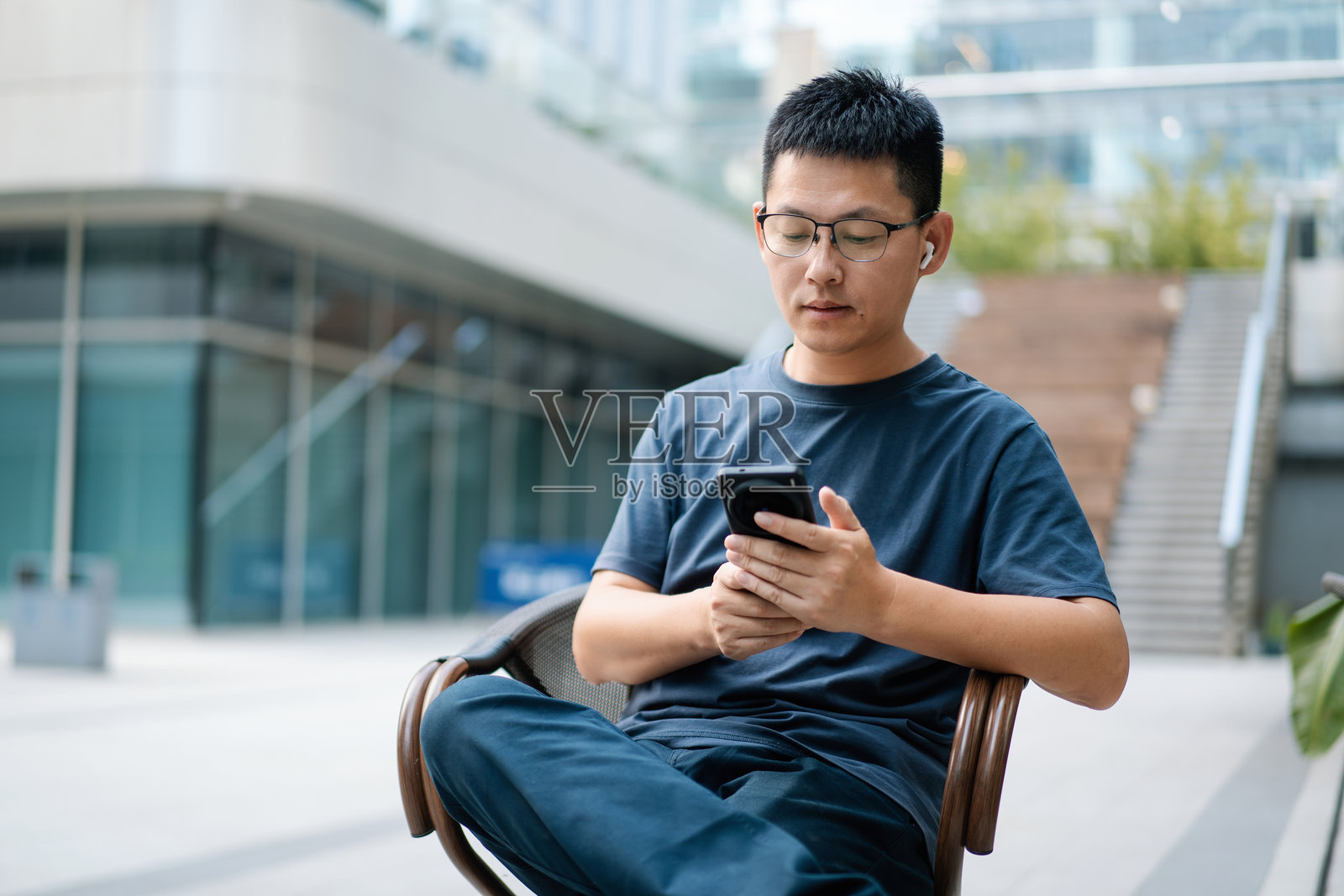 男子坐户外看手机照片摄影图片