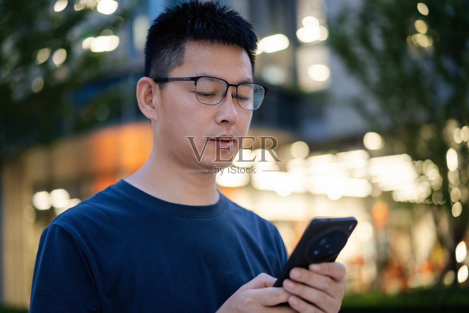 夜晚男子看手机照片摄影图片