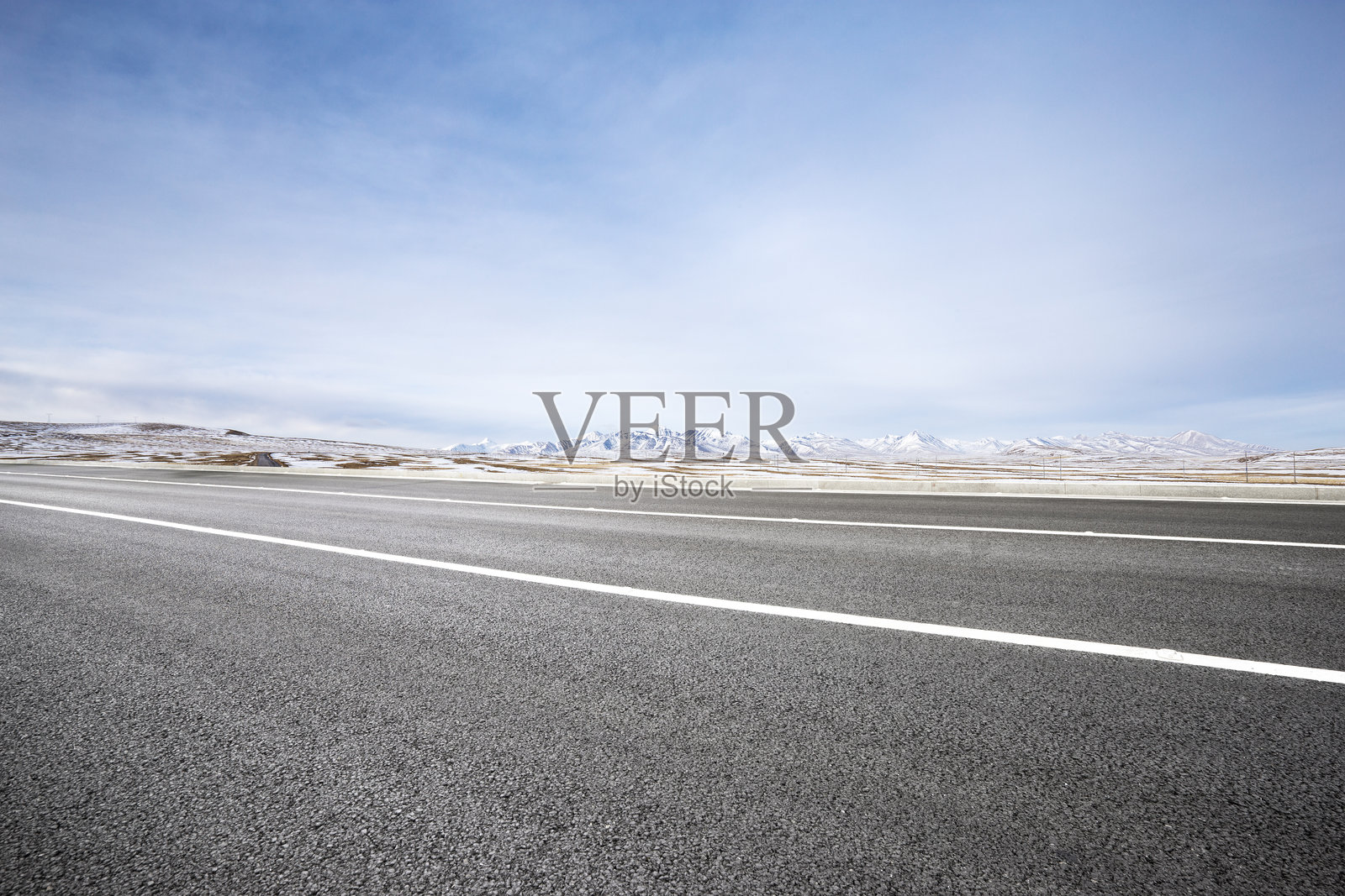 空旷沥青公路延伸至雪山背景下的荒漠高原照片摄影图片