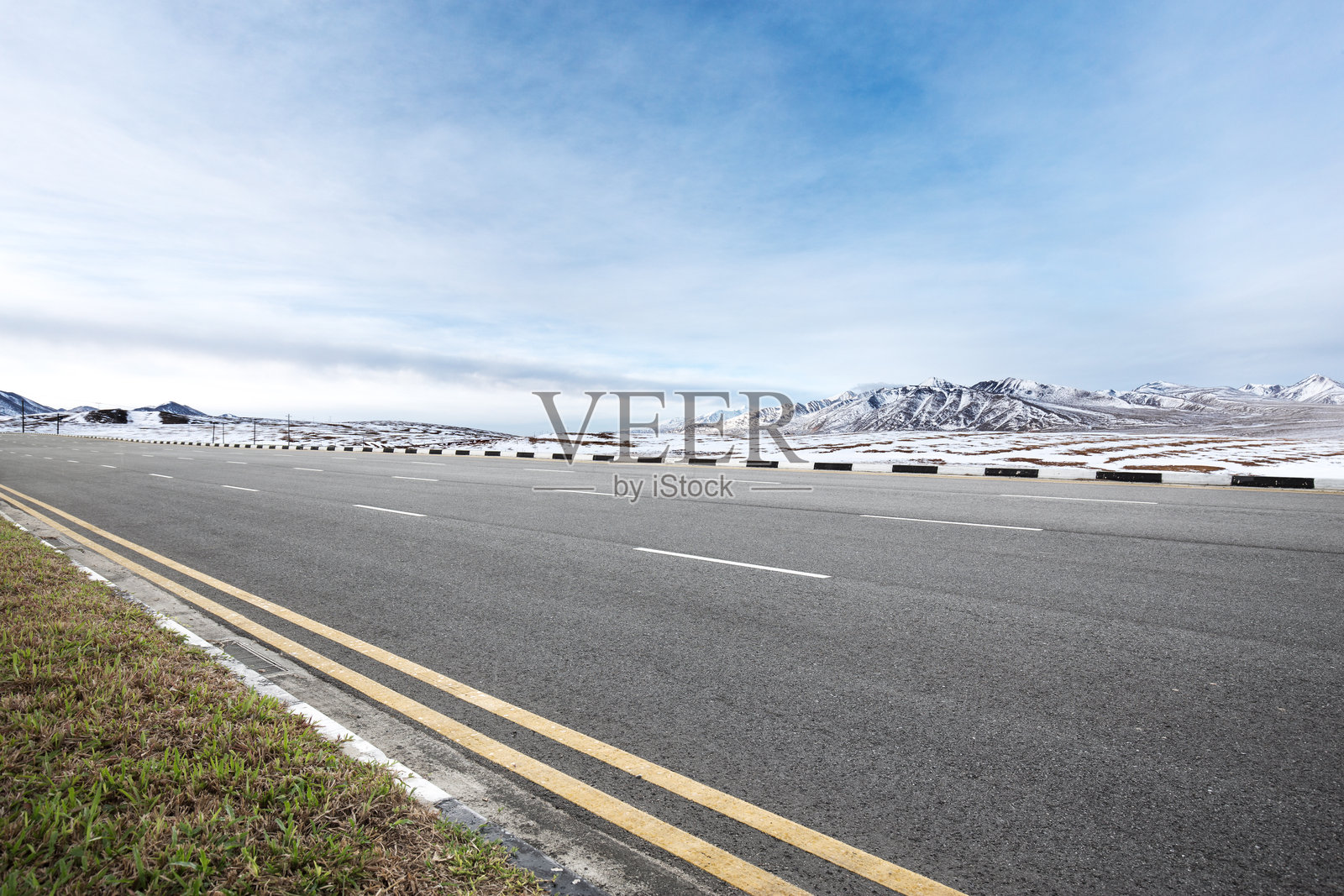 空旷沥青公路延伸至雪山背景下的高原景观照片摄影图片