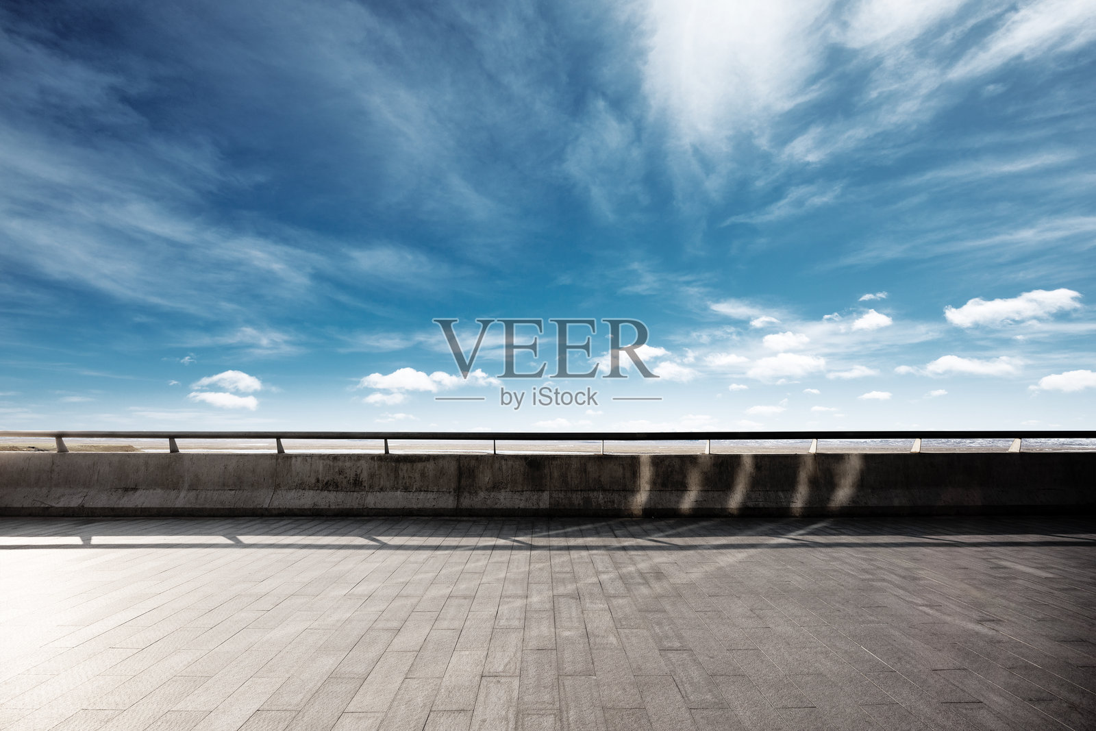 晴朗蓝天下的空旷混凝土平台与金属护栏照片摄影图片