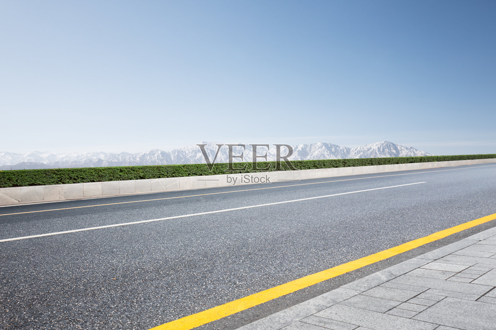 空旷沥青公路旁绿篱雪山远景蓝天照片摄影图片