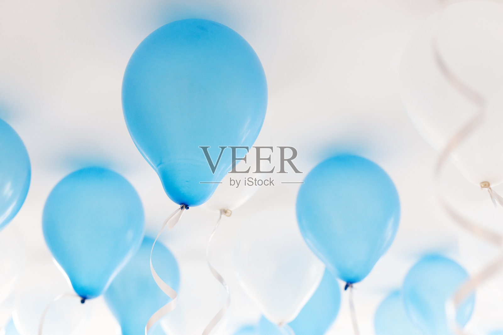 浅蓝色气球漂浮于白色背景中营造节日氛围照片摄影图片
