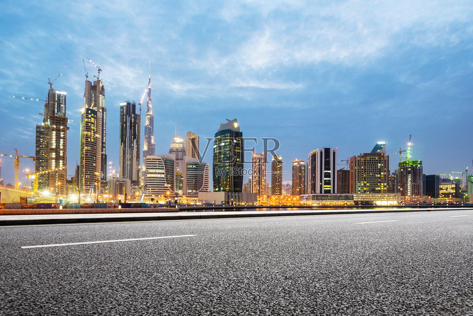 黄昏时分迪拜城市天际线与空旷沥青道路前景照片摄影图片