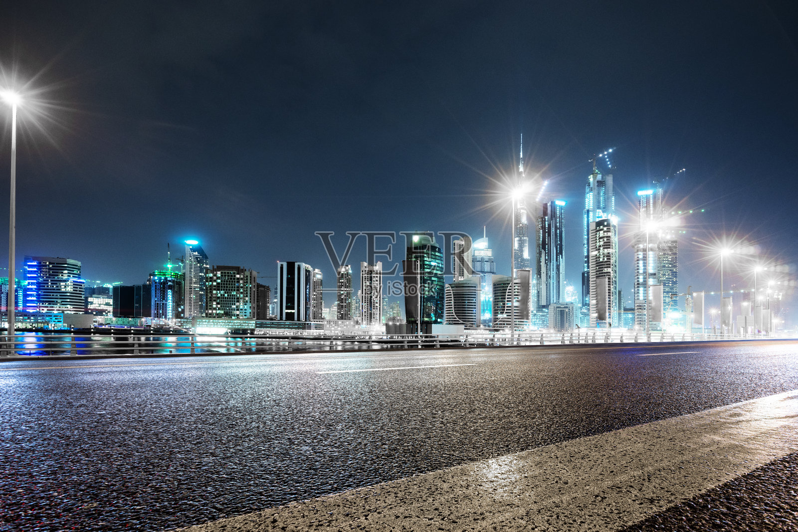 夜晚湿润路面映照迪拜城市天际线灯光璀璨照片摄影图片