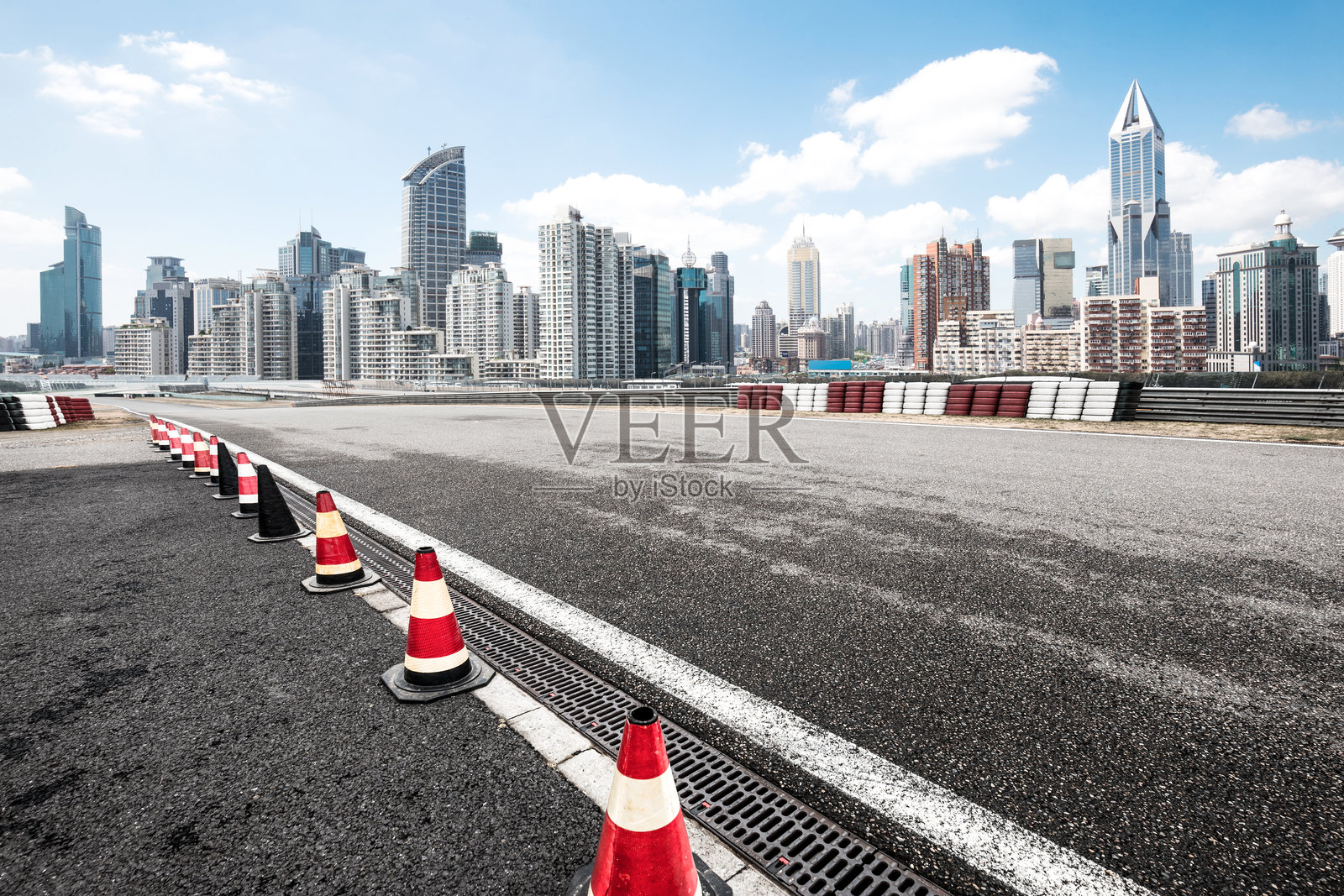 城市天际线前空旷沥青赛道与交通锥排列场景照片摄影图片