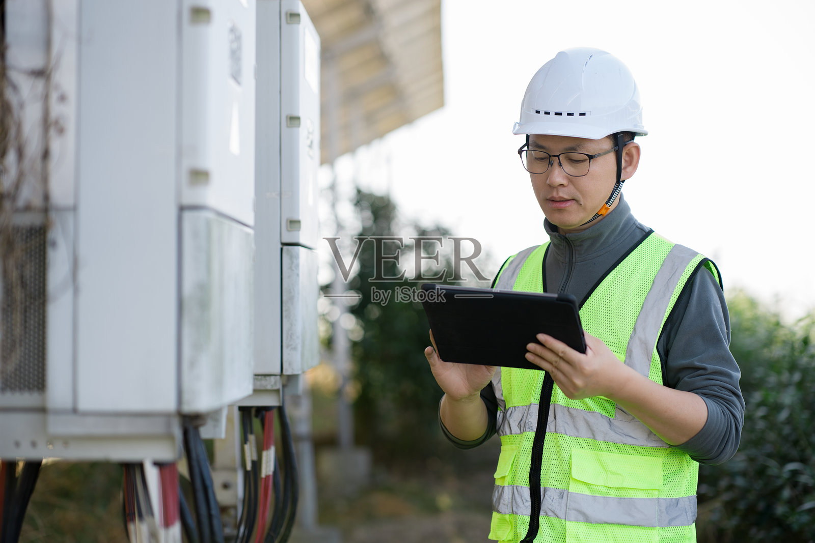 电力工程师现场巡检使用平板设备照片摄影图片