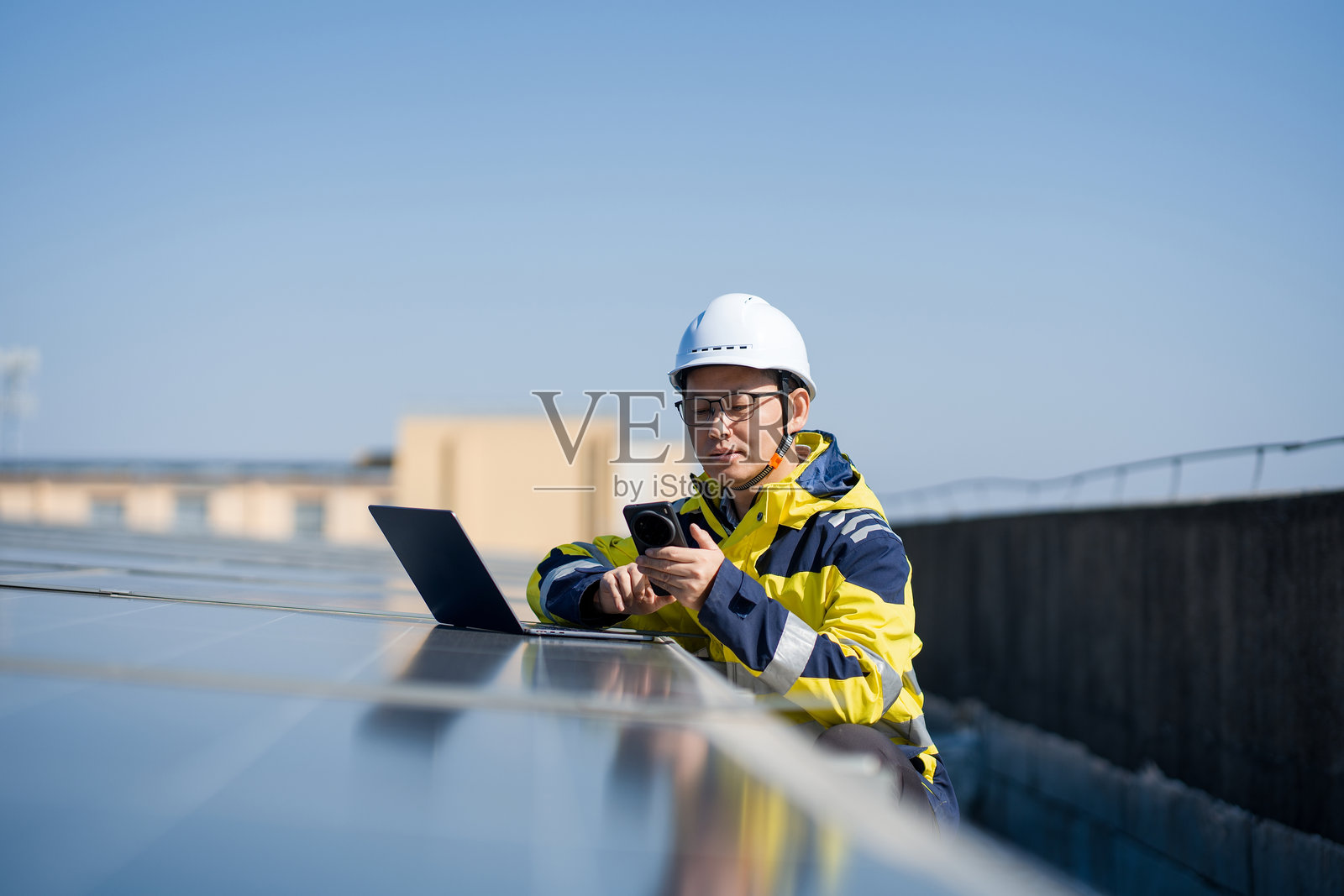 工程师屋顶检测光伏板使用笔记本手机照片摄影图片