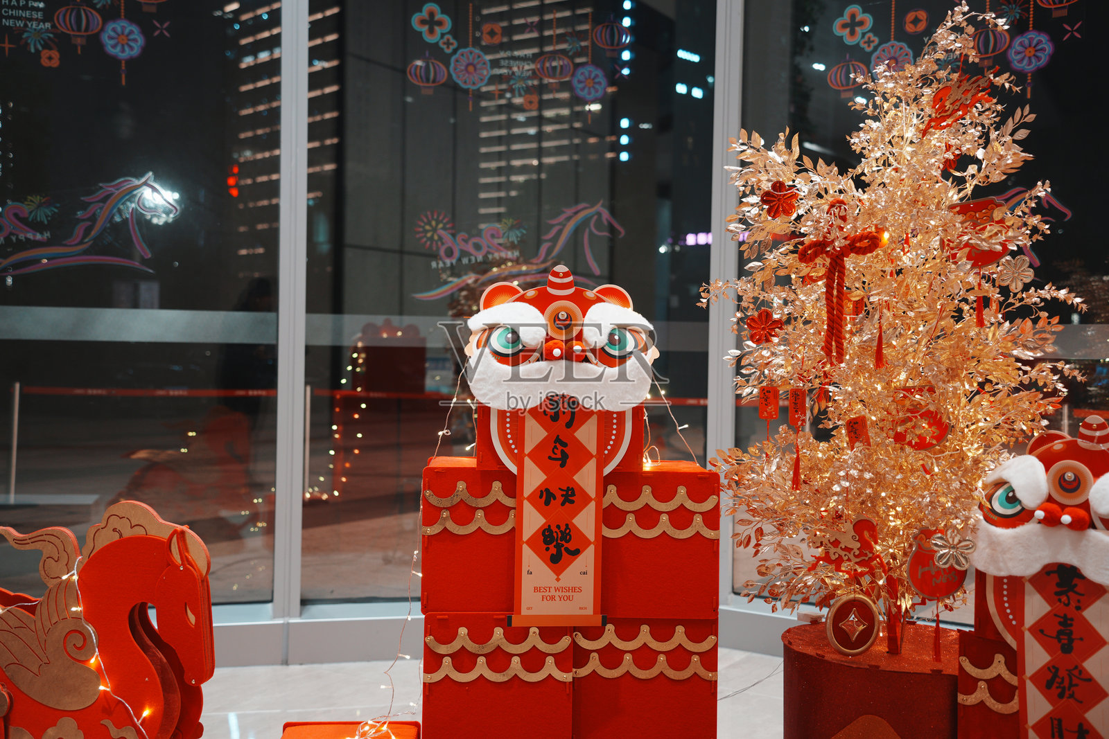 红色醒狮装饰与金箔树节日布景照片摄影图片
