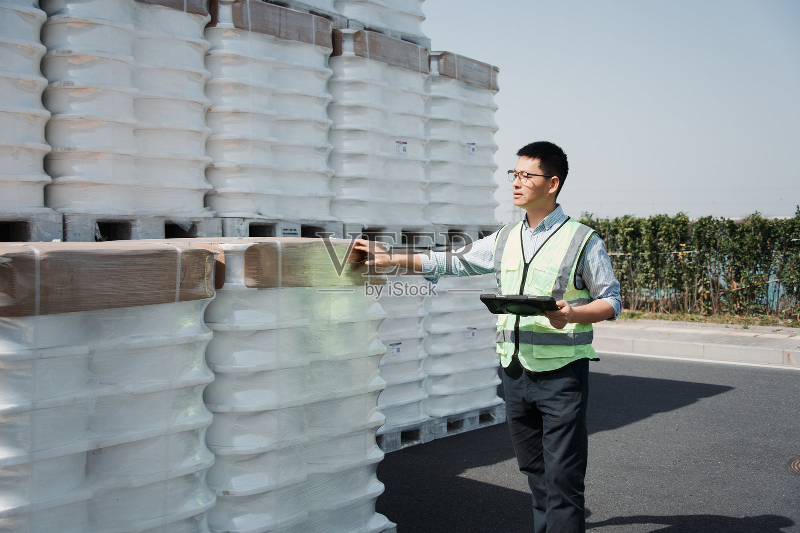 仓库管理员手持平板检查堆叠货箱照片摄影图片