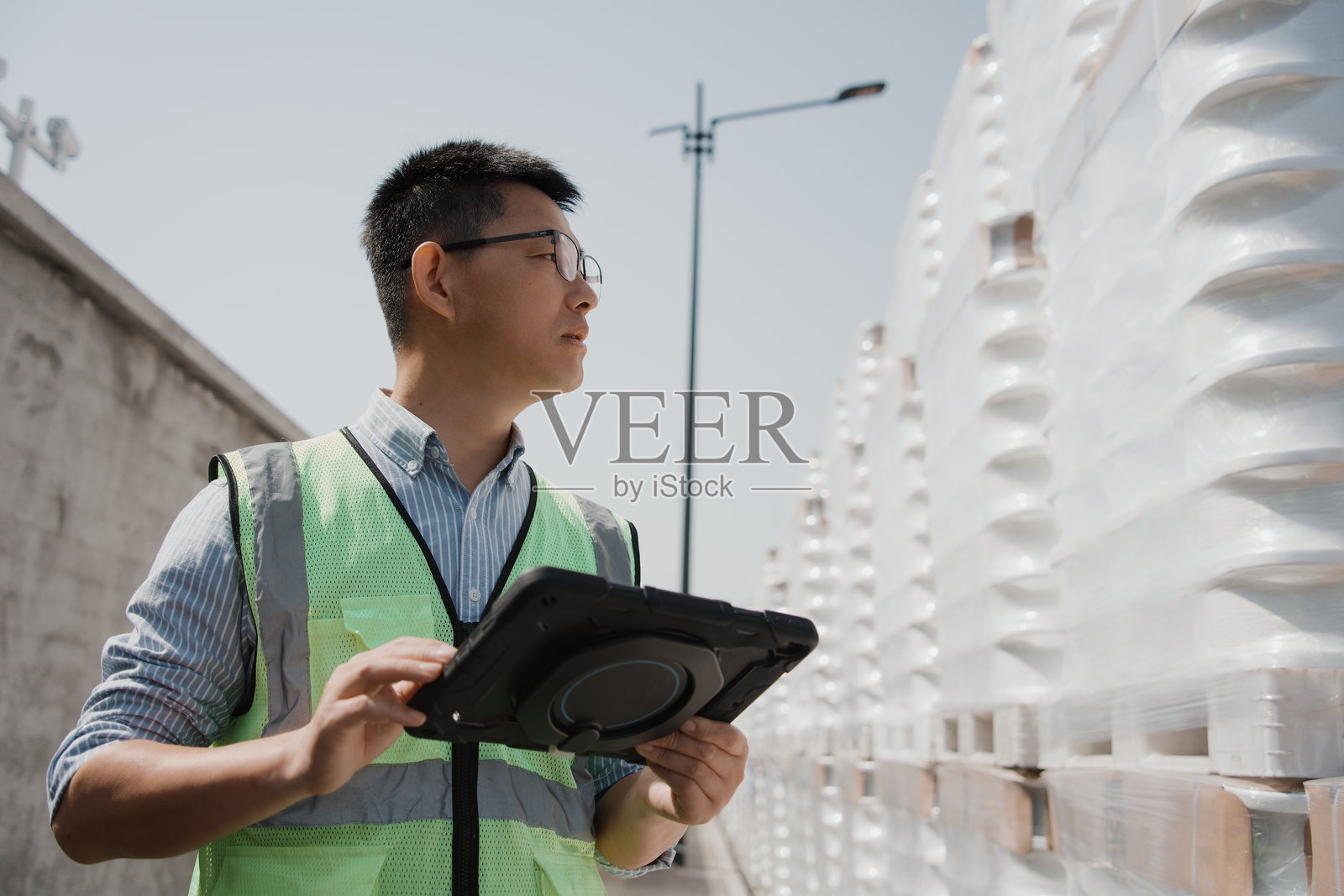 仓库管理员手持平板检查货物堆垛照片摄影图片