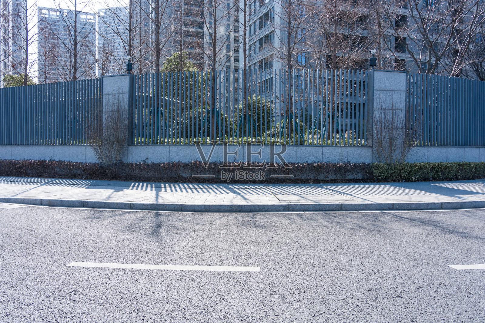 城市道路旁金属围栏与高层建筑景观照片摄影图片