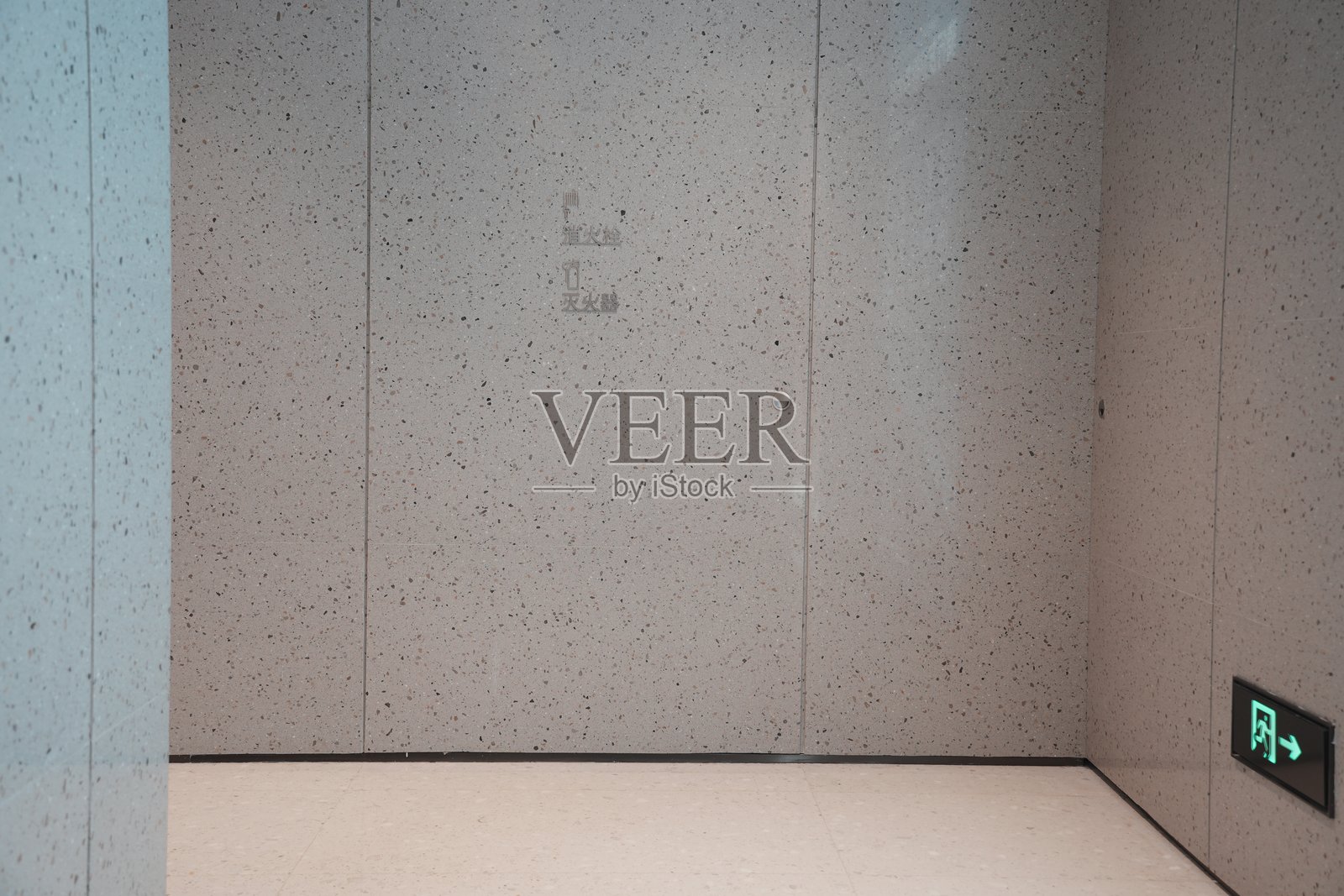 浅灰斑点墙面电梯间应急出口标识照片摄影图片